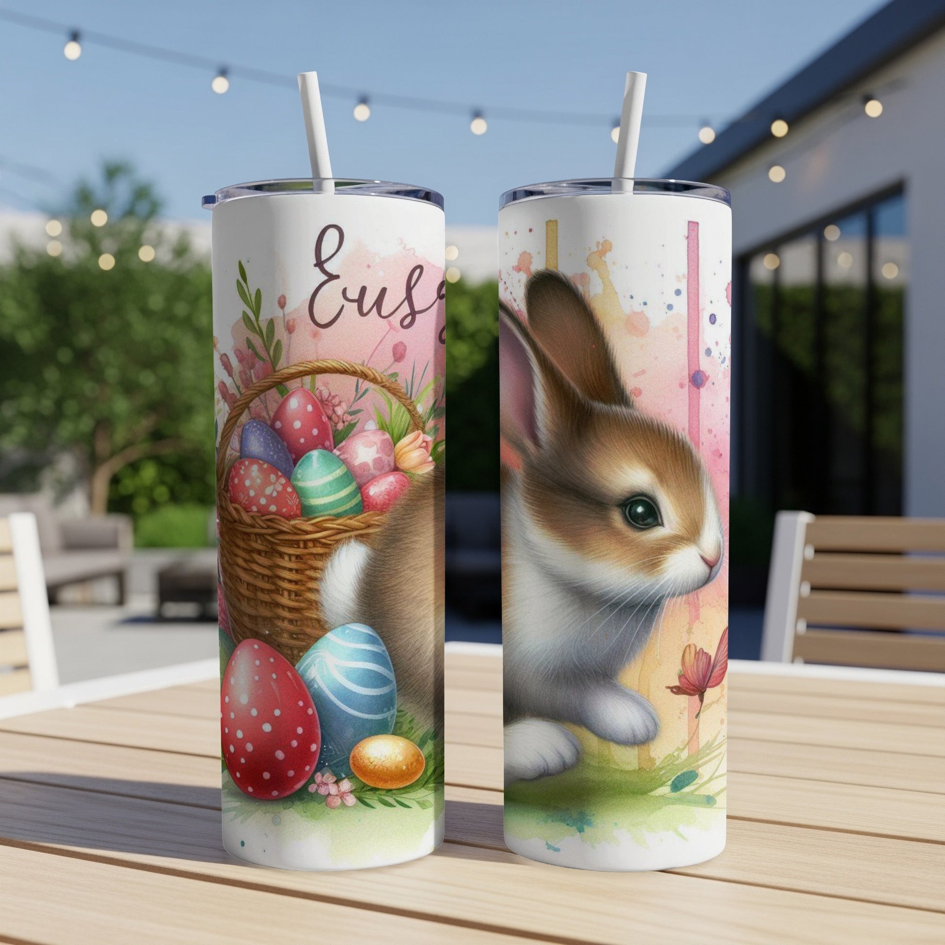 Two Easter-themed tumblers with bunnies and decorated eggs on a table.
