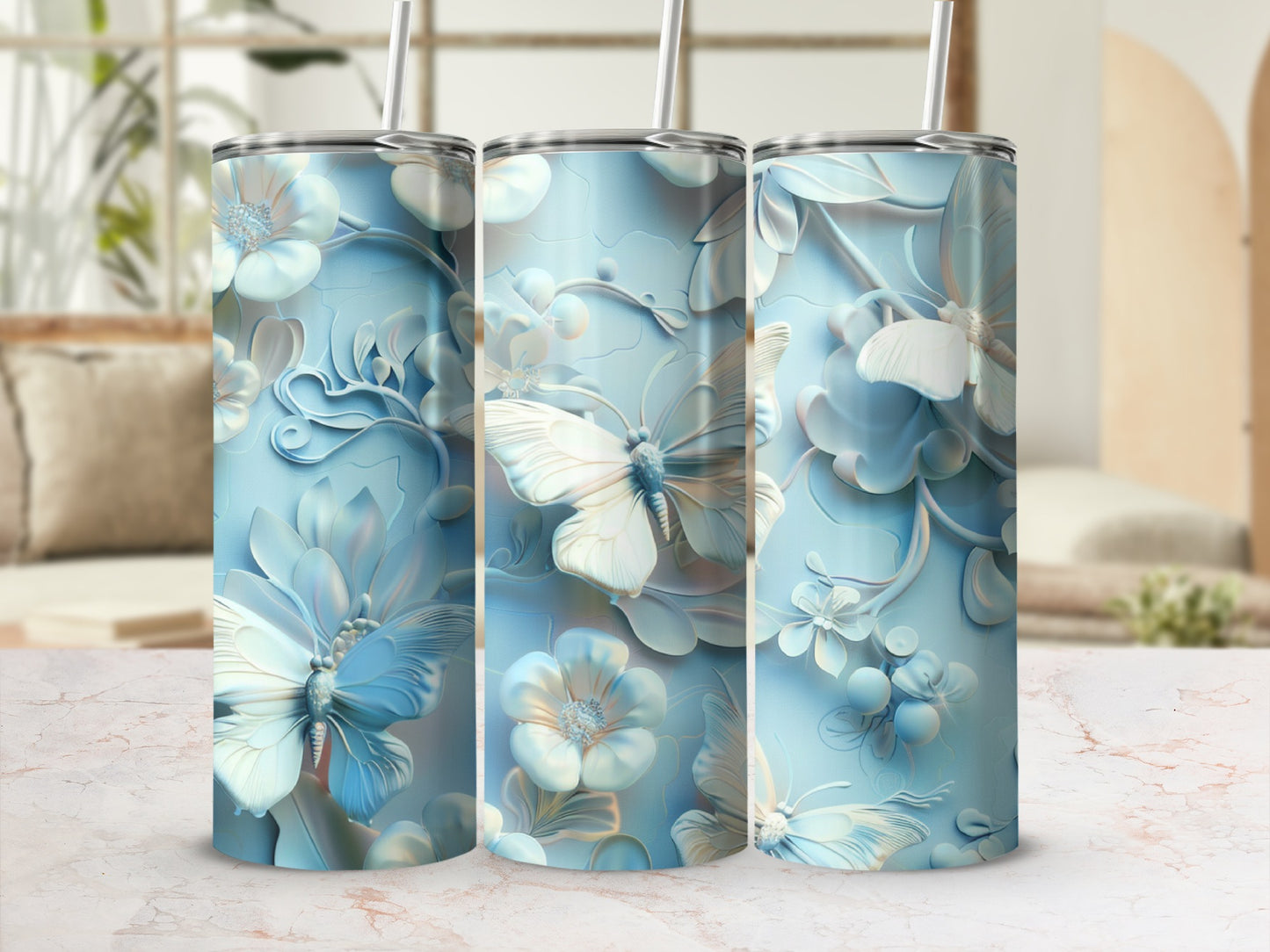 Three pastel blue tumblers with embossed butterfly and floral designs.