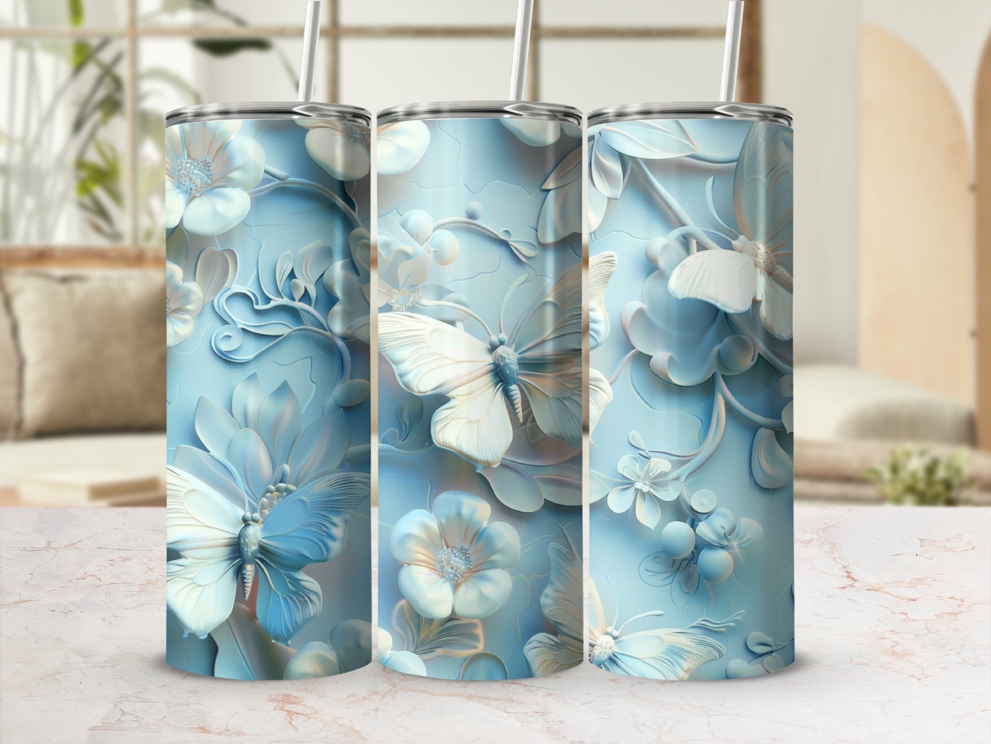 Three pastel blue tumblers with embossed butterfly and floral designs.