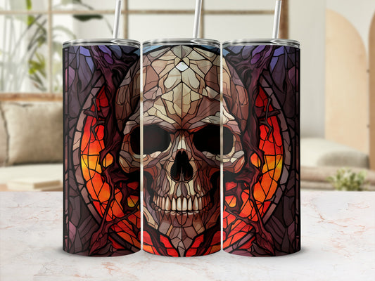 Stained glass skull tumbler with straw on a marble surface.