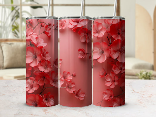 Three pink floral tumblers with straws on a marbled countertop.