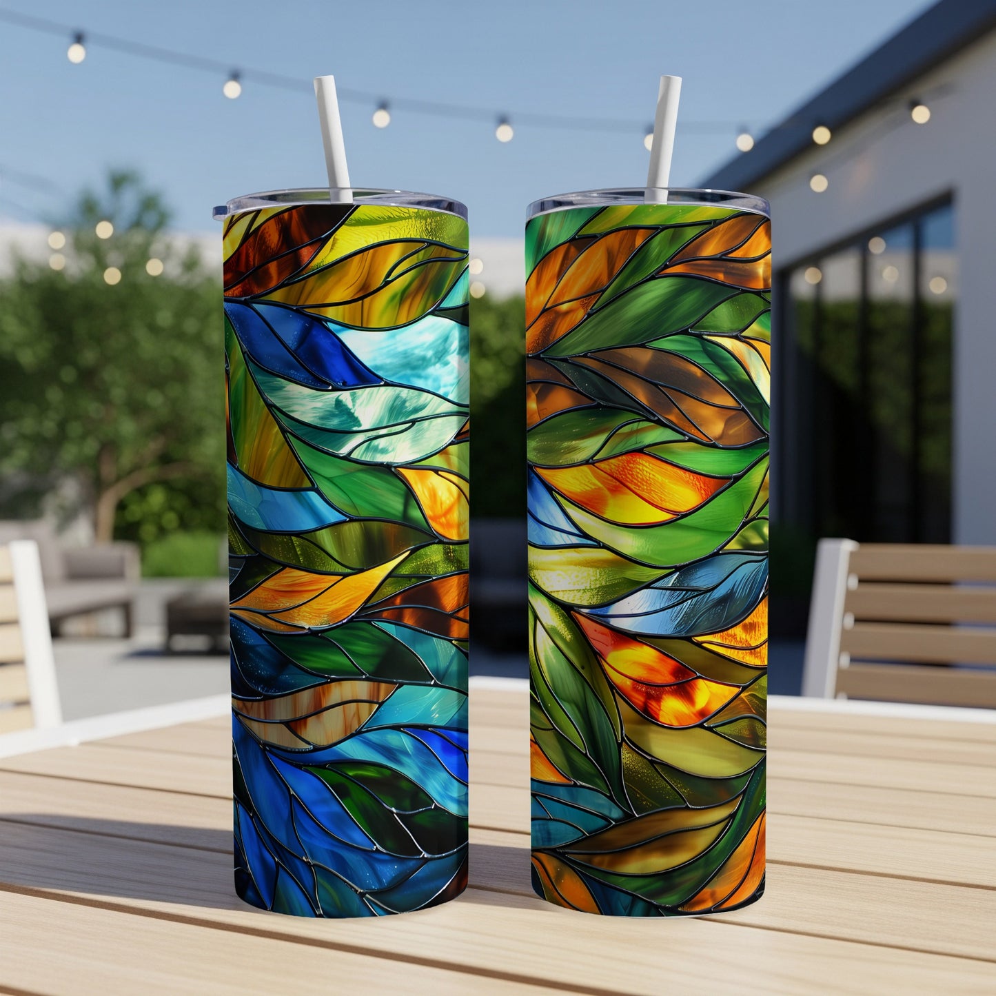 Two stained glass patterned tumblers on a wooden table.