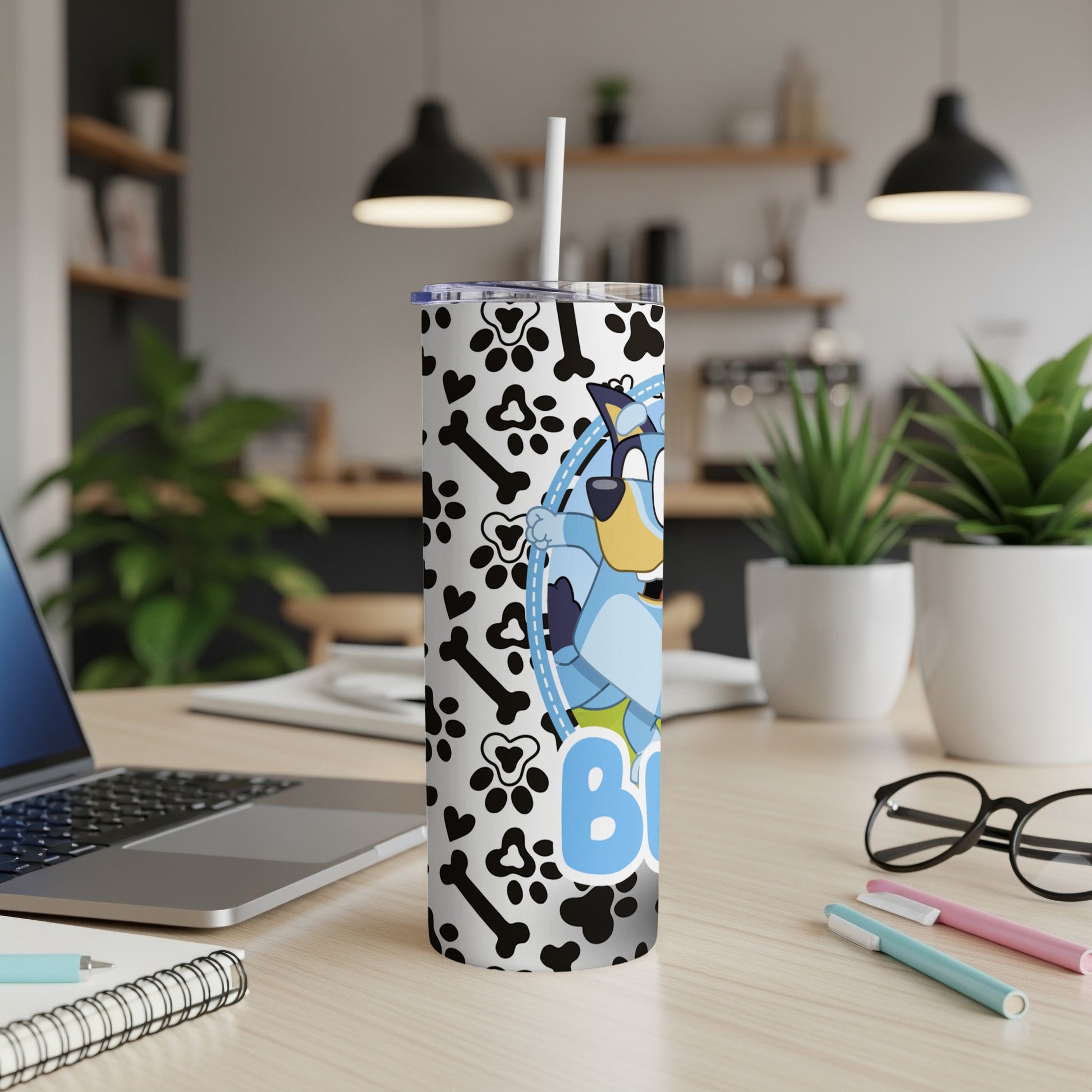 Bluey character on a black and white paw print and bone patterned skinny tumbler.