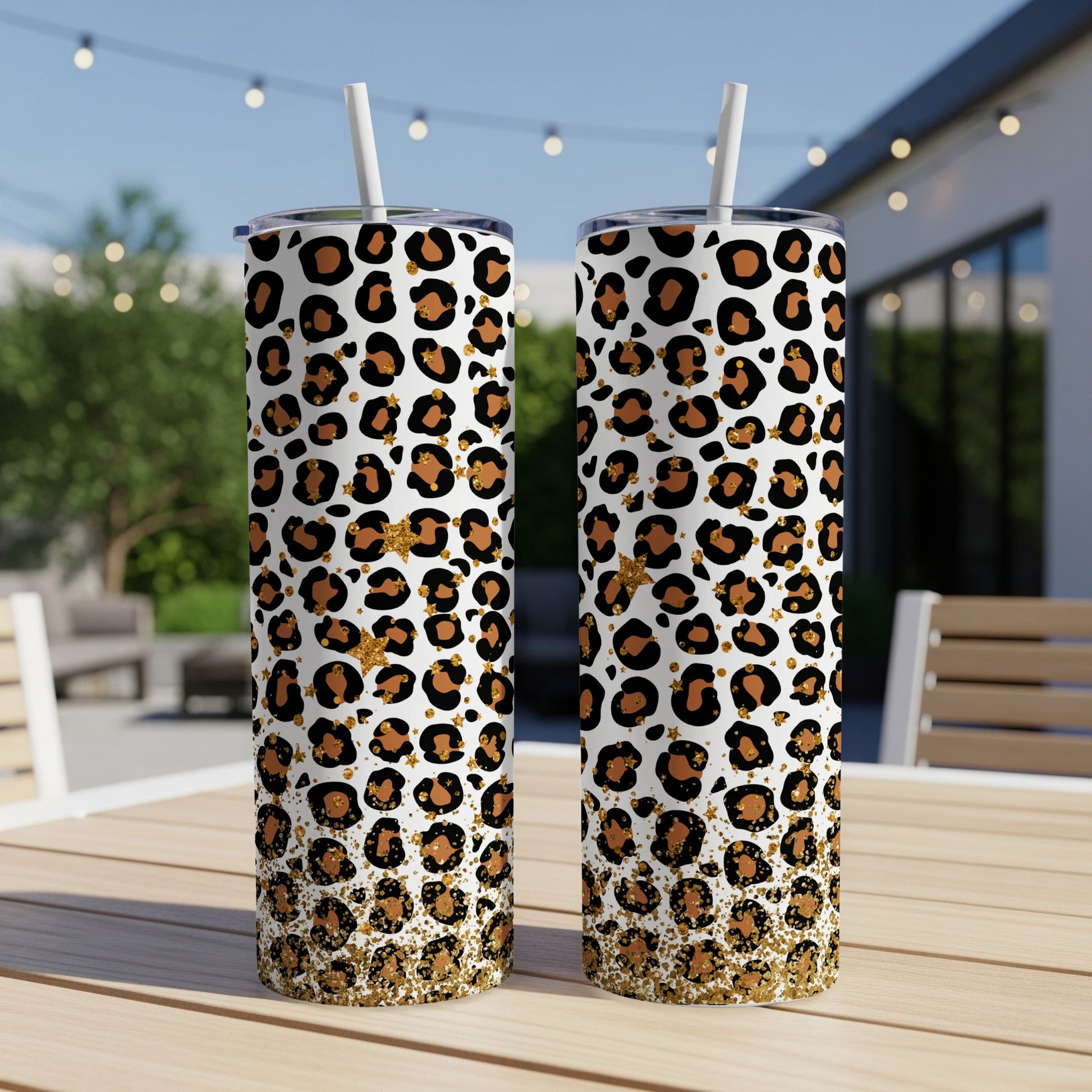 Two leopard print tumblers with gold glitter accents on a table.