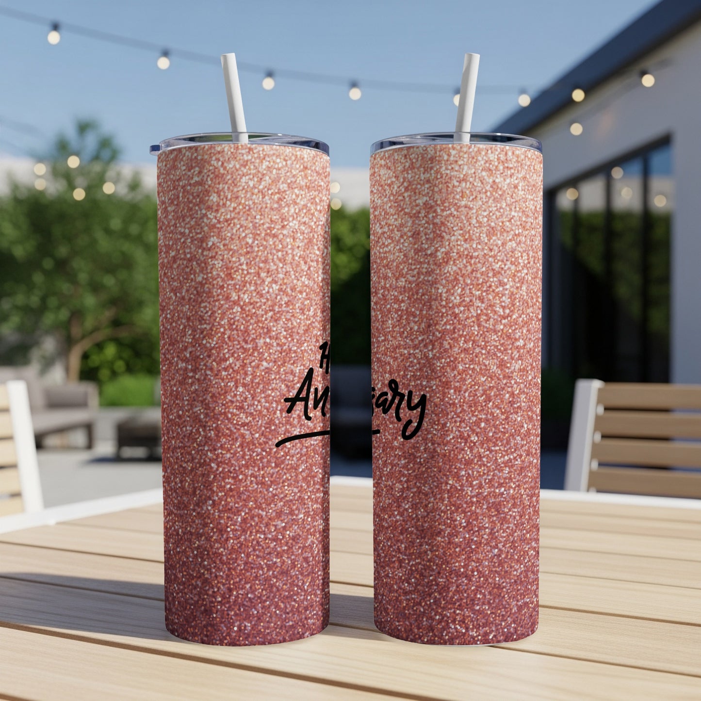 Rose gold glitter tumbler with "Anniversary" text on a table.