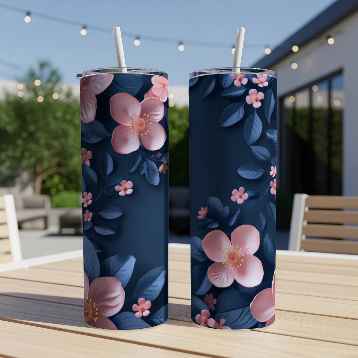 Two navy blue tumblers with pink cherry blossoms and green leaves design.