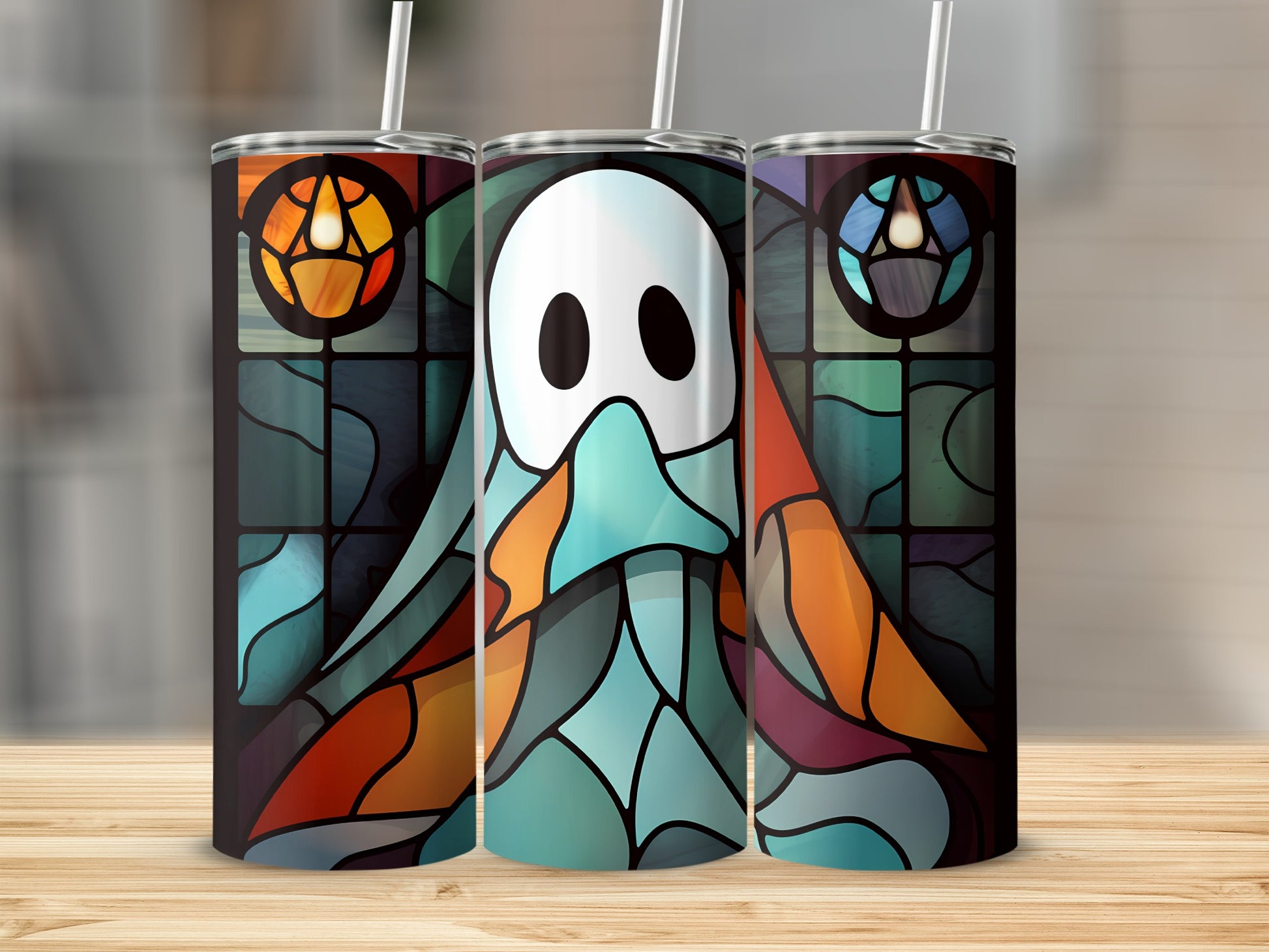 Ghost stained glass design on three tumblers on a wooden surface.