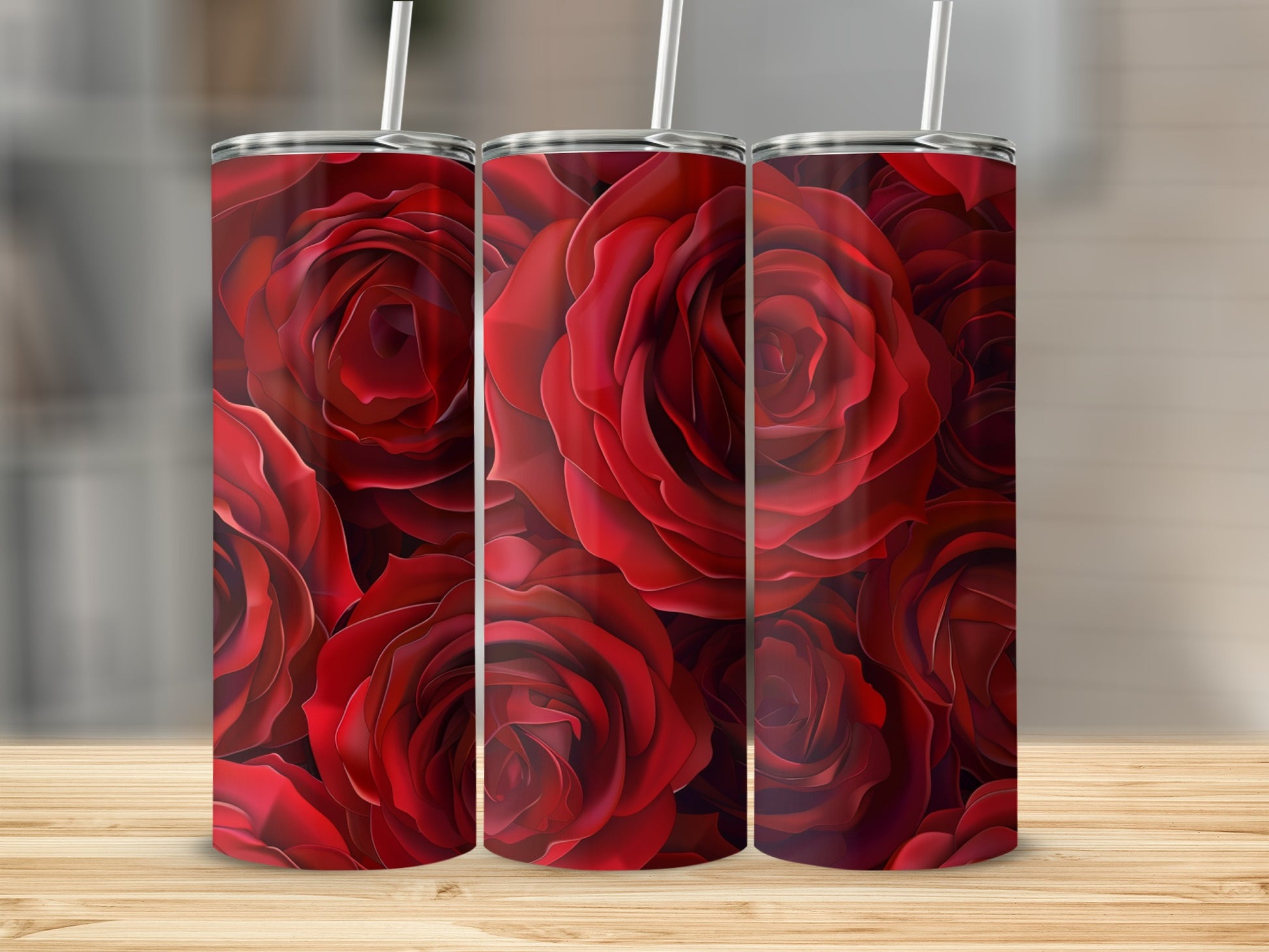 Three red rose tumblers on a wooden surface.