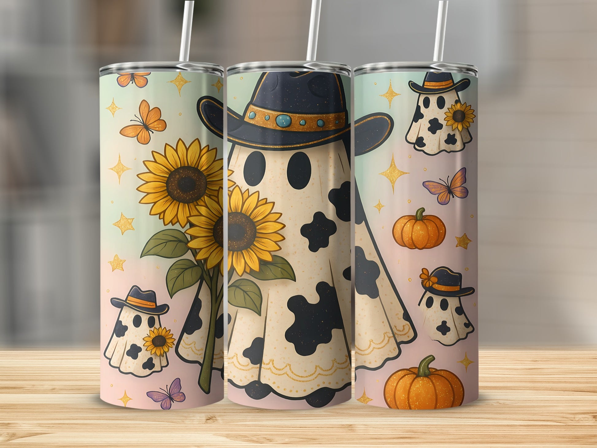 Three tumblers featuring cow-print ghosts in cowboy hats with sunflowers and pumpkins.