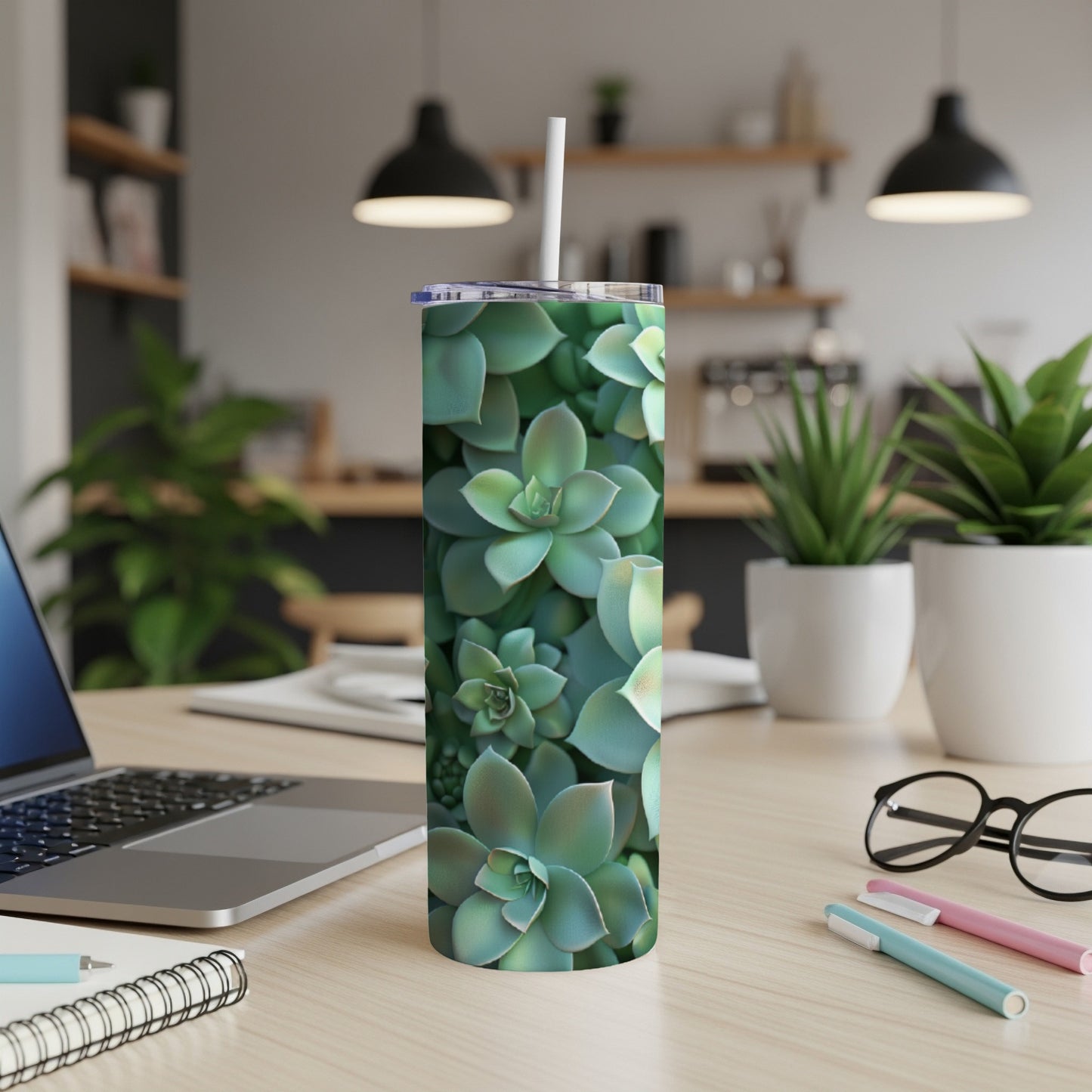 Green succulent plants covering a white tumbler with a straw.
