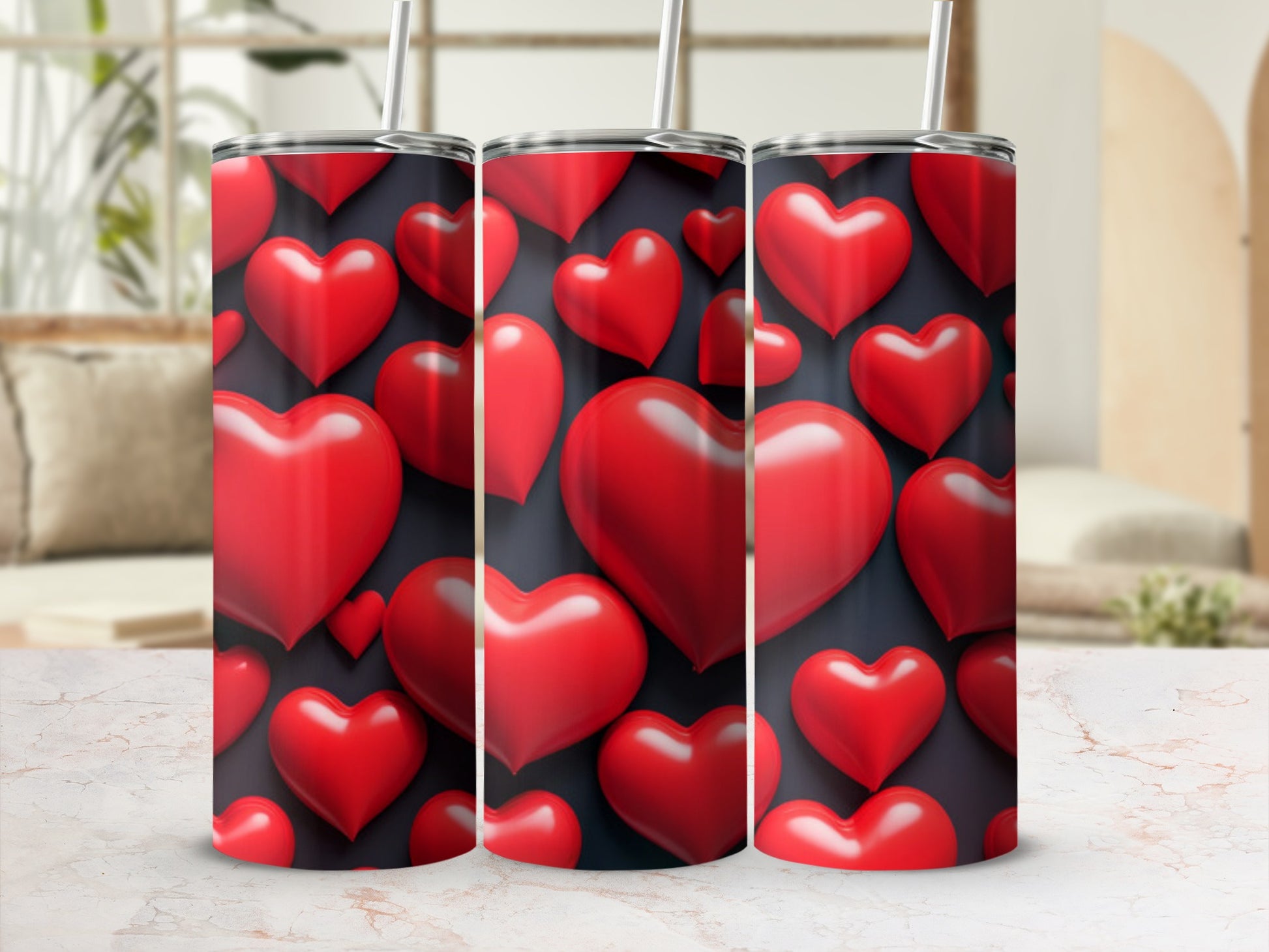 Three red heart-patterned tumblers with straws on a marble surface.