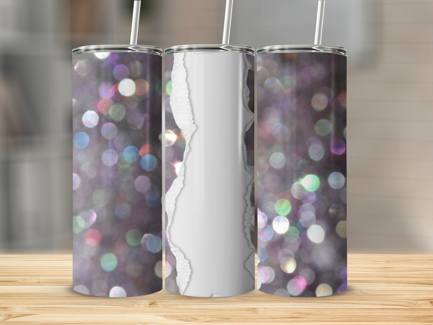 Three glitter tumblers with torn paper designs sit on a wooden surface.