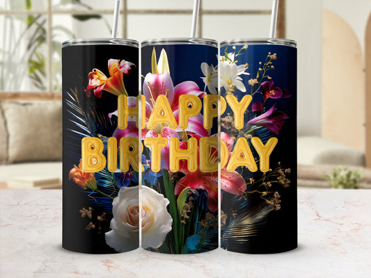 Tumbler with "Happy Birthday" text and floral design against a blurred background.