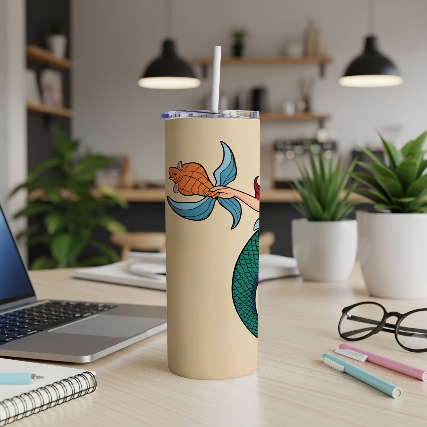 Tan tumbler with a cartoon mermaid holding a fish and a turtle.