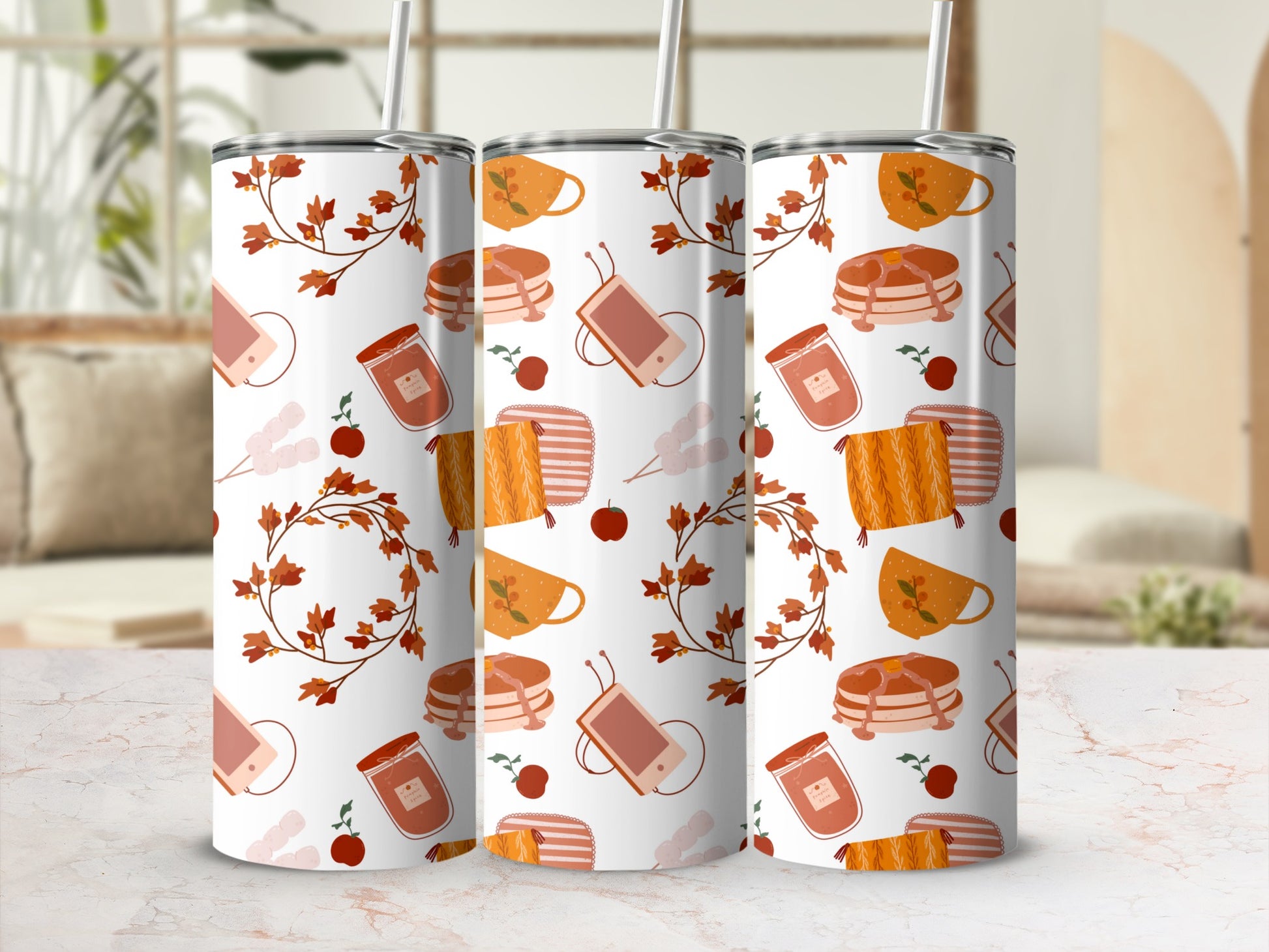 Three tumblers with autumn leaf and jar patterns on a marble surface.