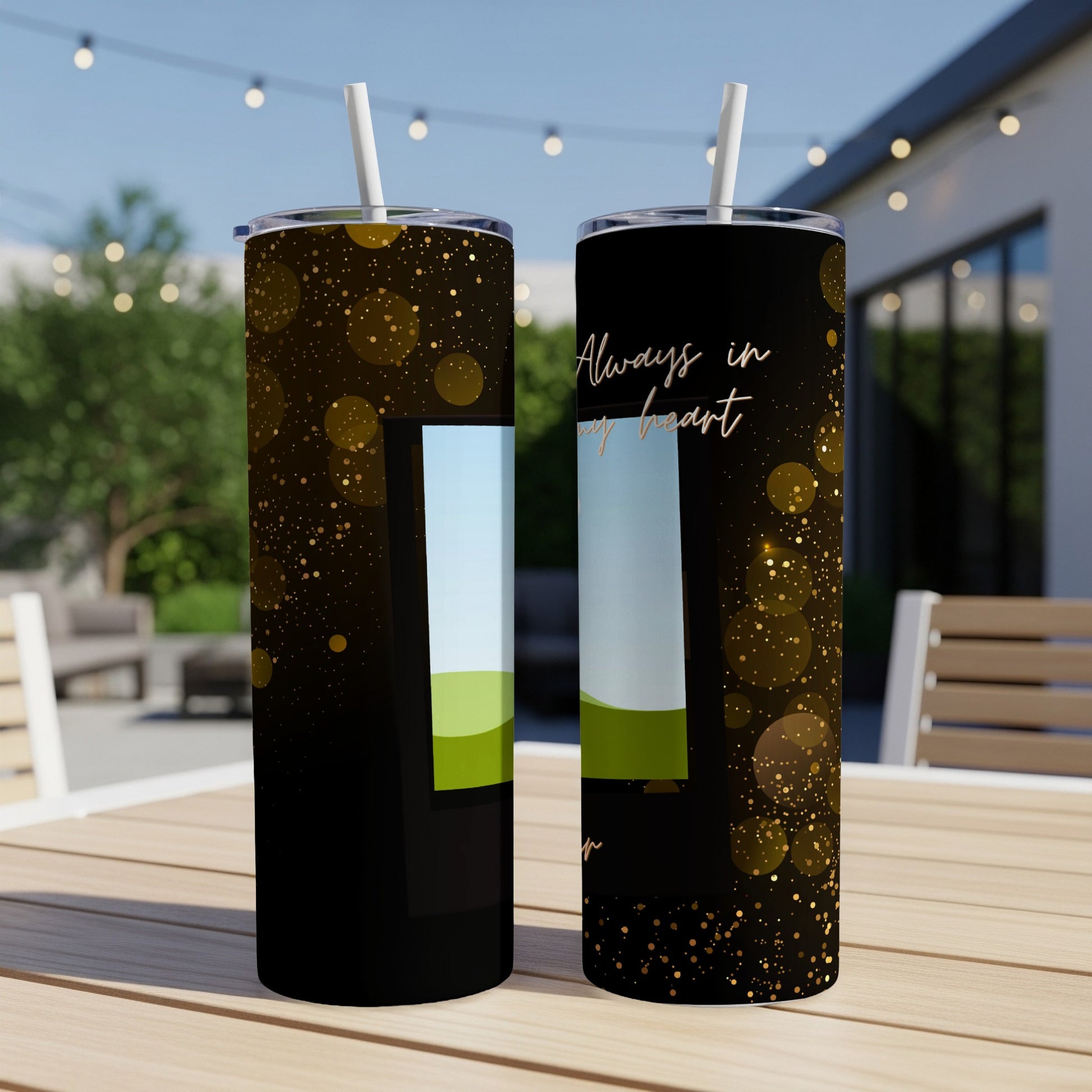 Two black tumblers with gold bokeh, featuring a landscape scene and text "Always in my heart."