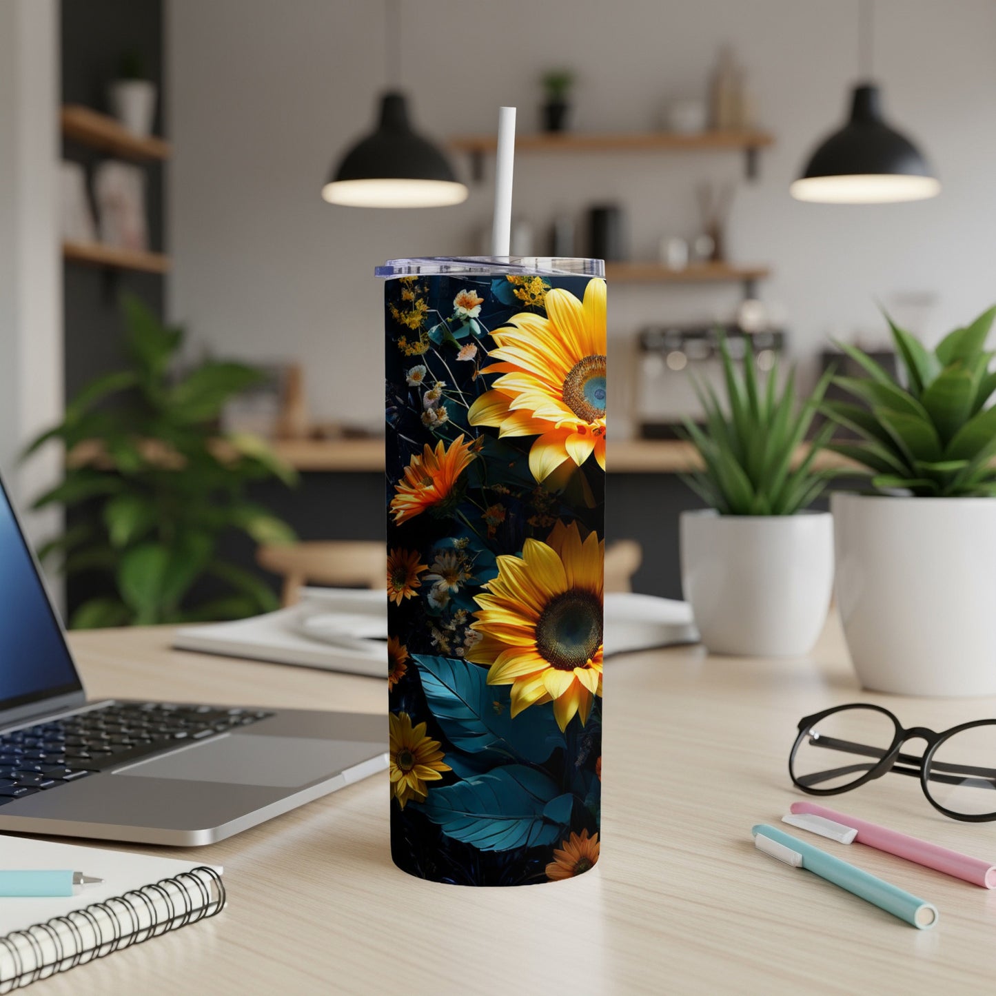 Sunflower tumbler with lid and straw on a desk.