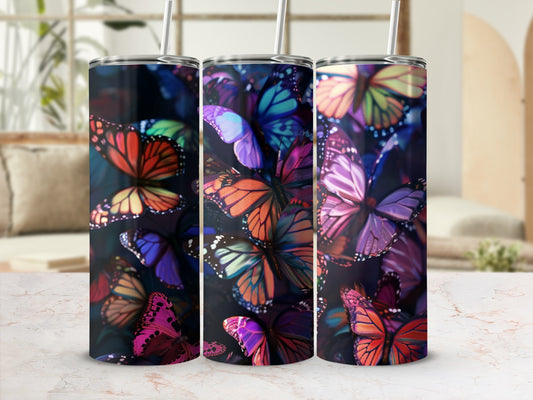 Tumbling colorful butterflies cover this cylindrical tumbler with straws.