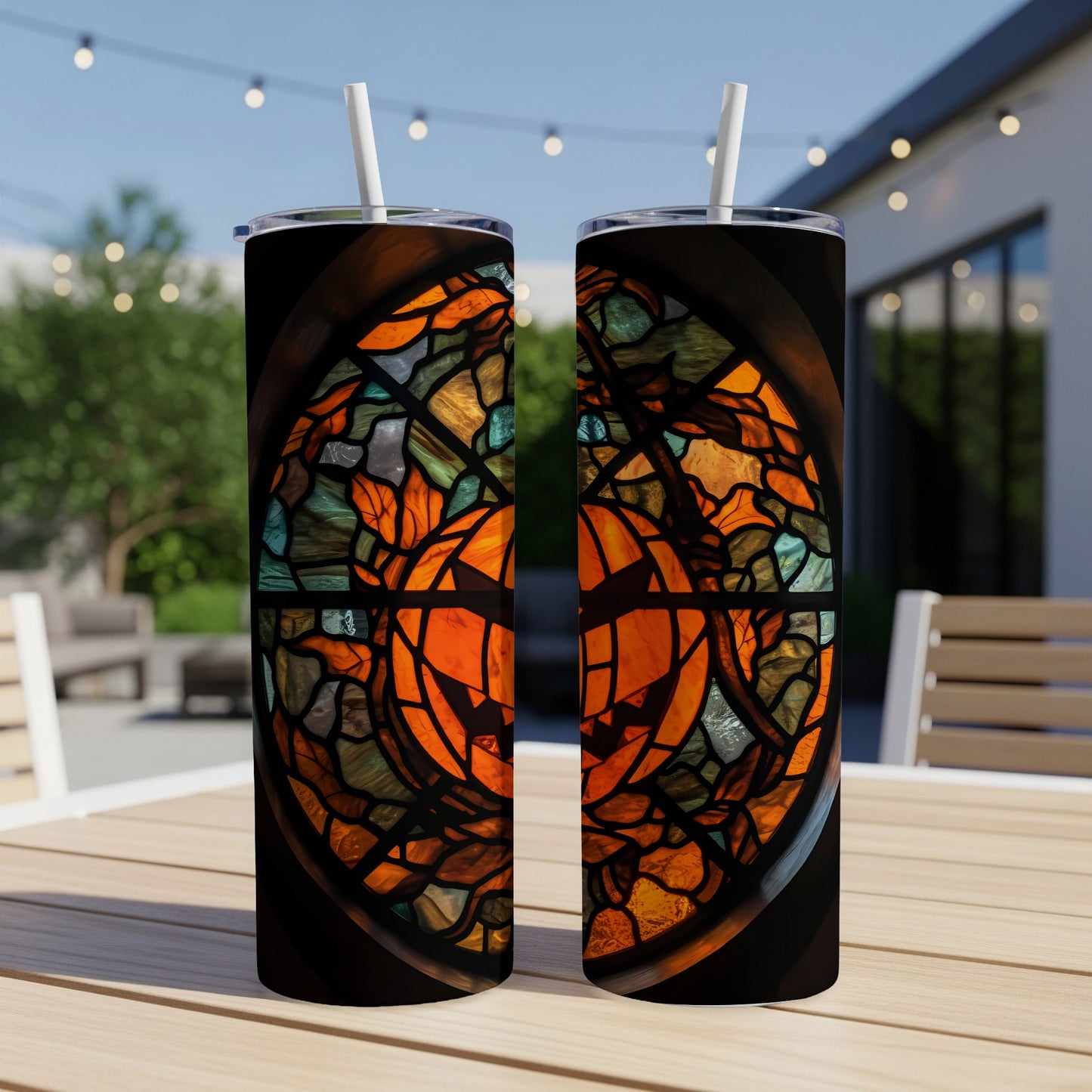 Two tumblers with stained glass pumpkin design on a table.