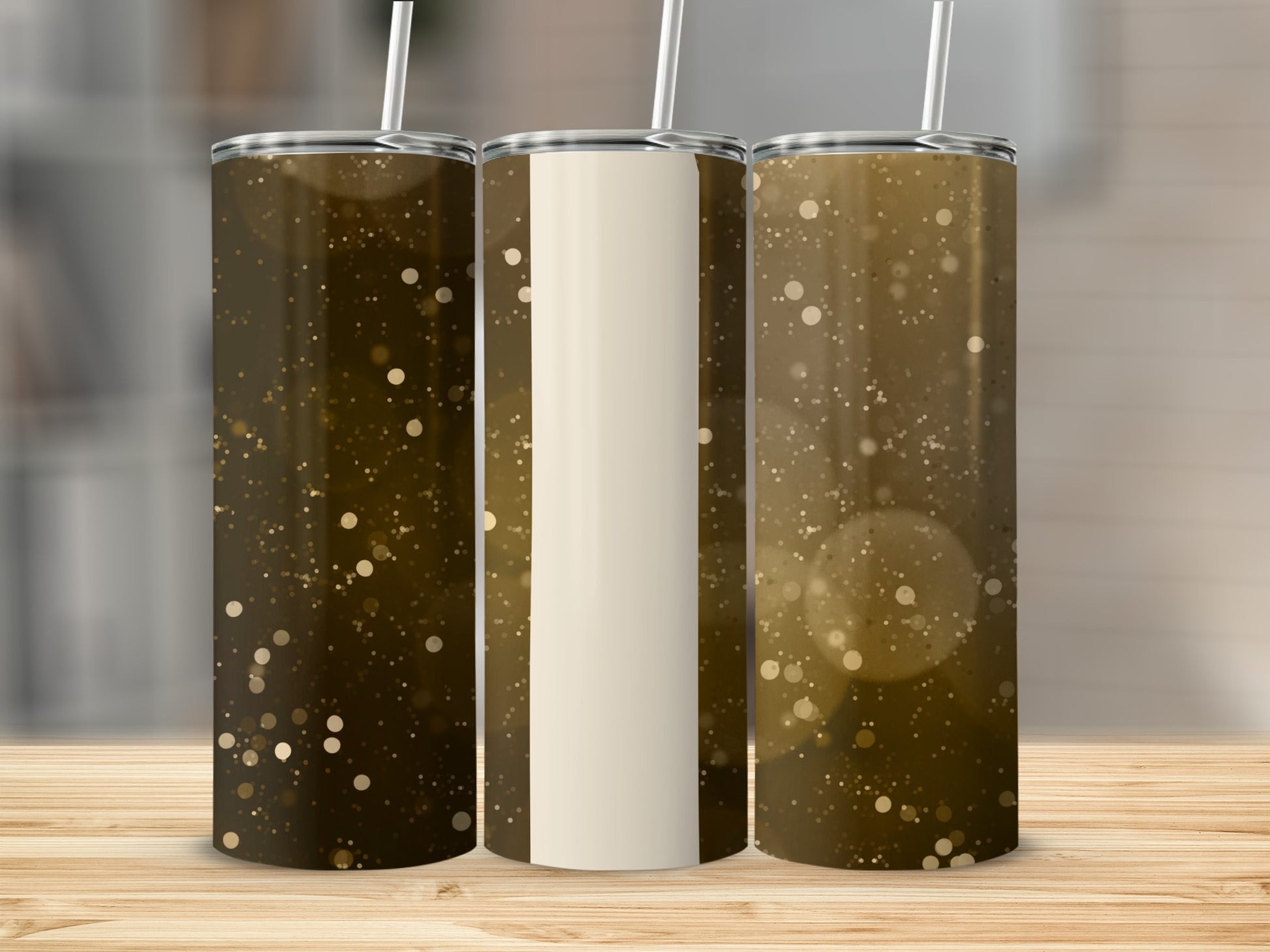 Three tumblers with a golden bokeh glitter design on a wooden surface.