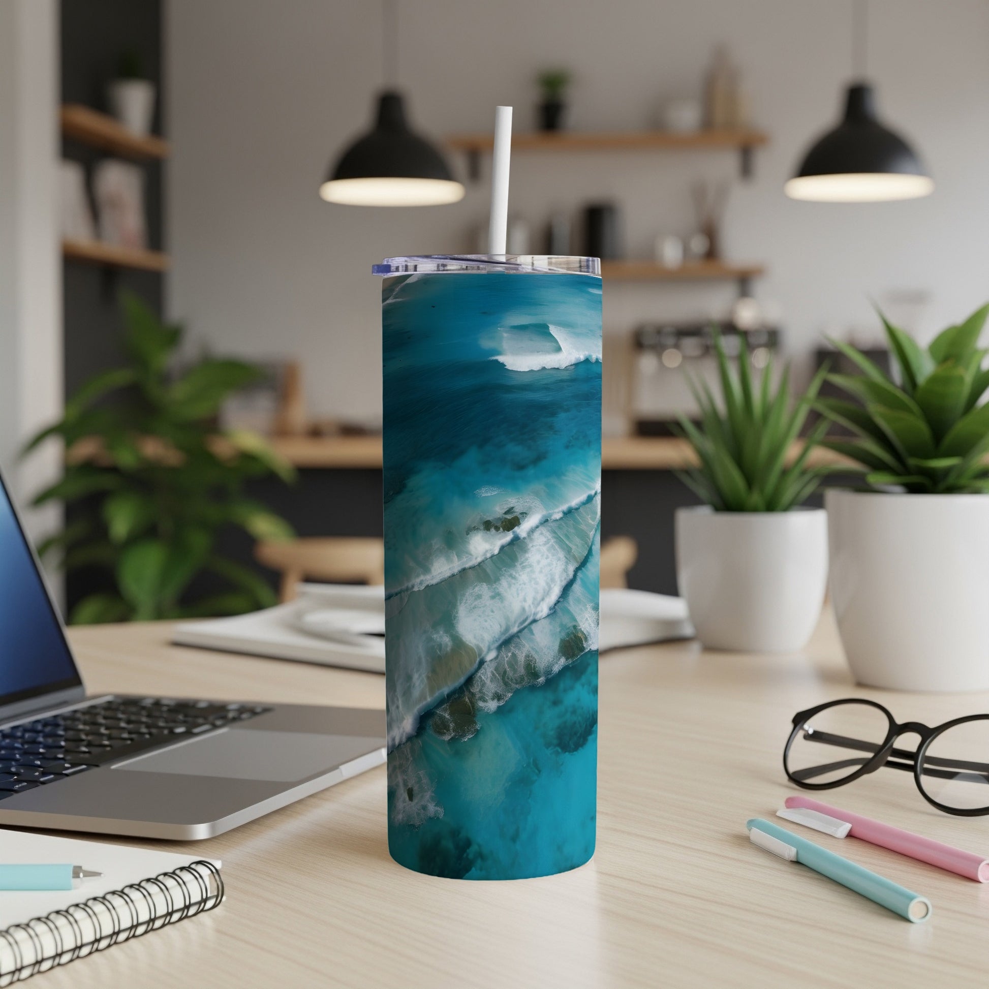 Turquoise ocean waves on a blue tumbler with a white straw.