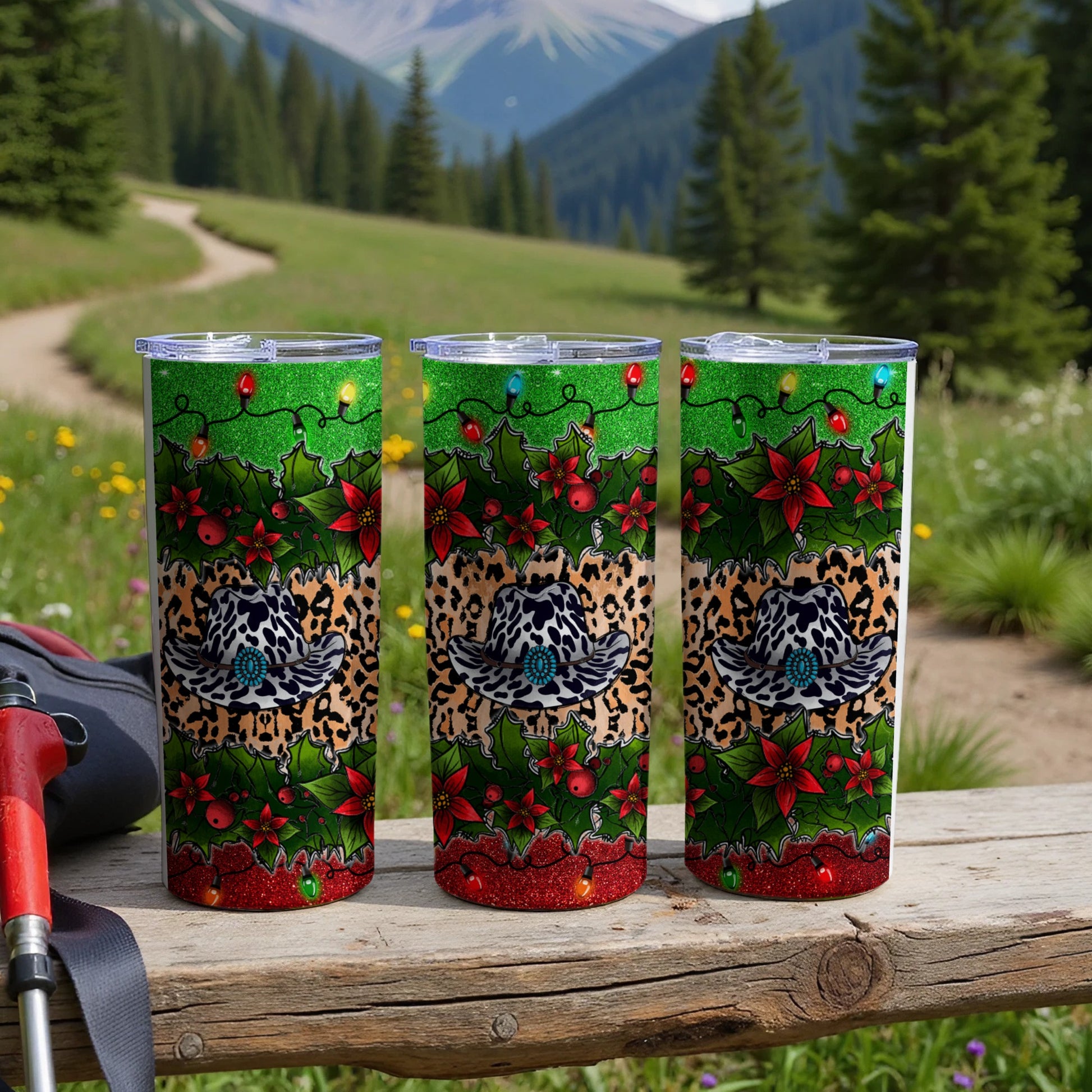 Three festive tumblers with Christmas lights, holly, and cheetah print hats.