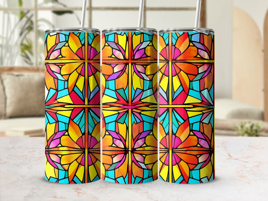 Three stained glass patterned tumblers with straws sit on a marbled surface.