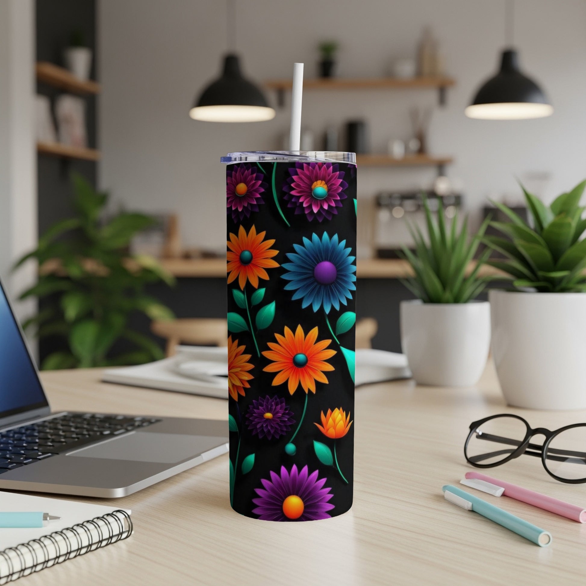 Black tumbler with vibrant floral pattern and white straw on desk.