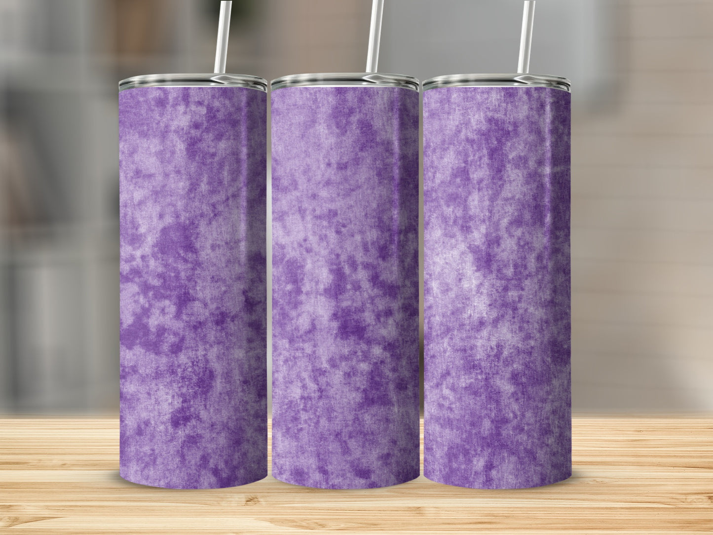 Three purple tumblers with a marble pattern and straws on a wooden surface.