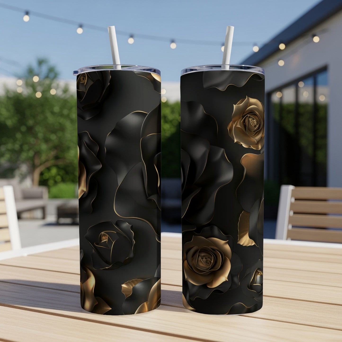 Two tall tumblers with black and gold rose pattern on a table.