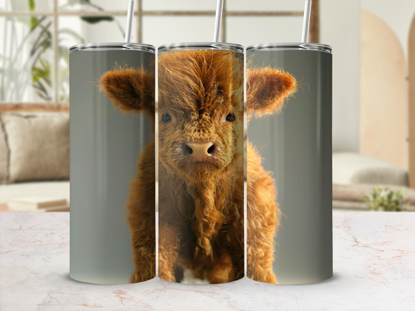 Three Highland cow tumblers displayed on a marbled surface with a blurred background.
