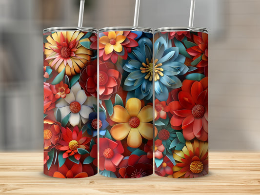 Three colorful floral tumblers with straws displayed on a wooden surface.
