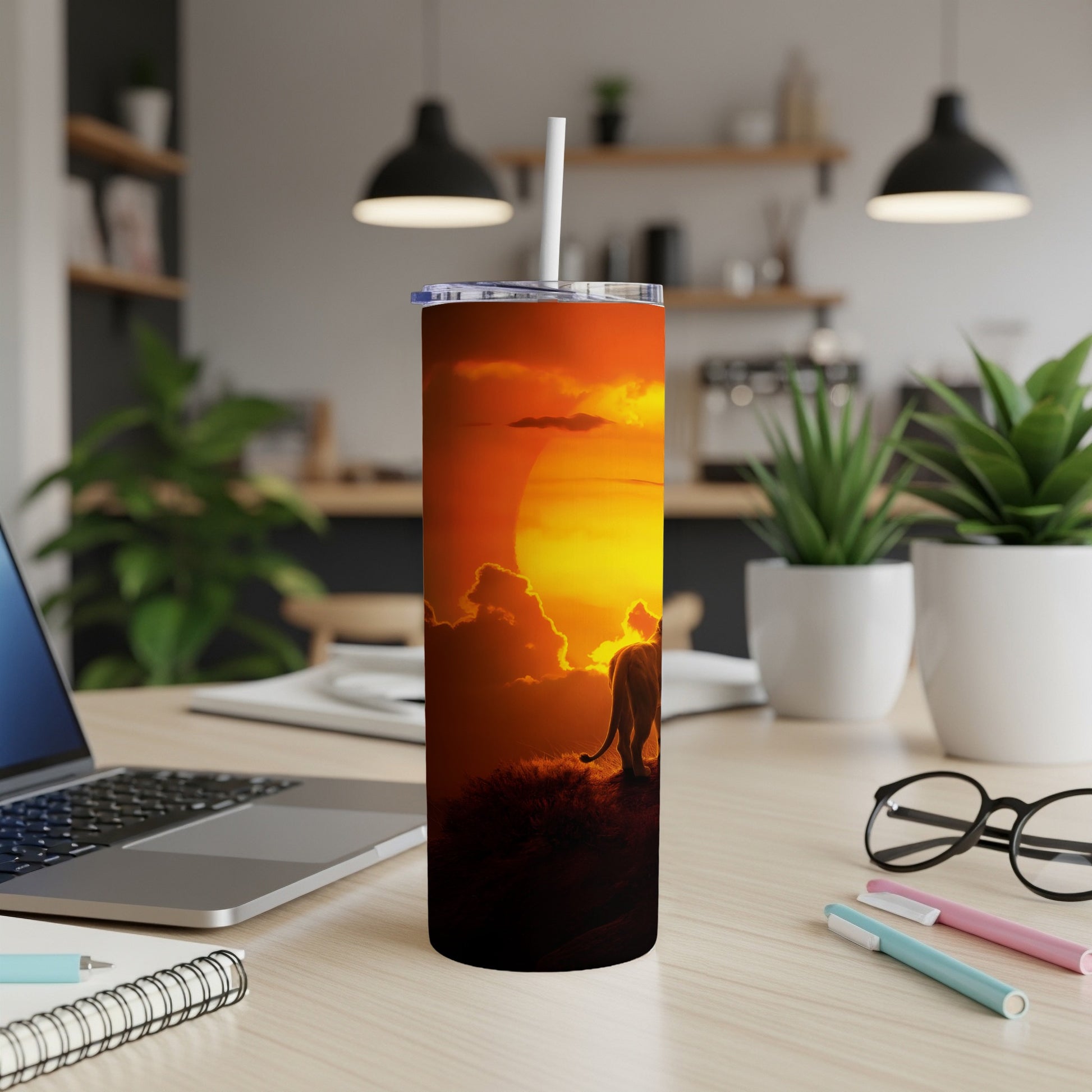 Lion silhouette against a dramatic sunset on a stainless steel tumbler.