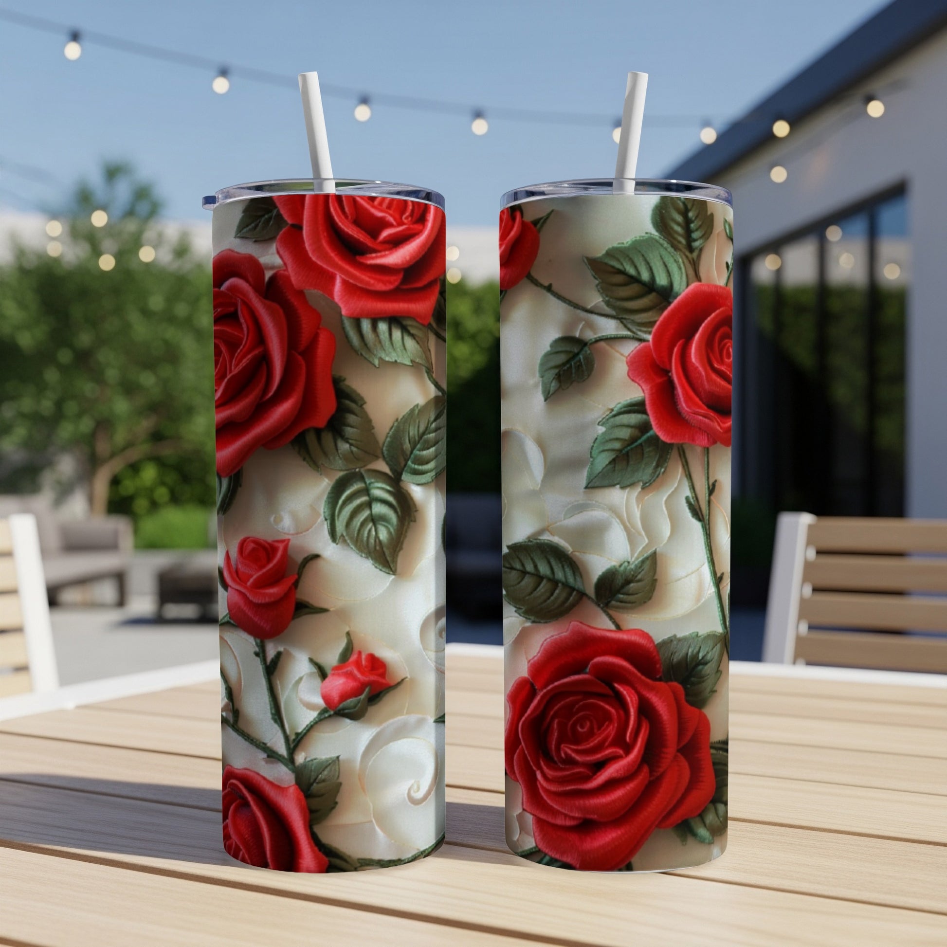 Two tumblers with a red rose floral pattern on a wooden table.