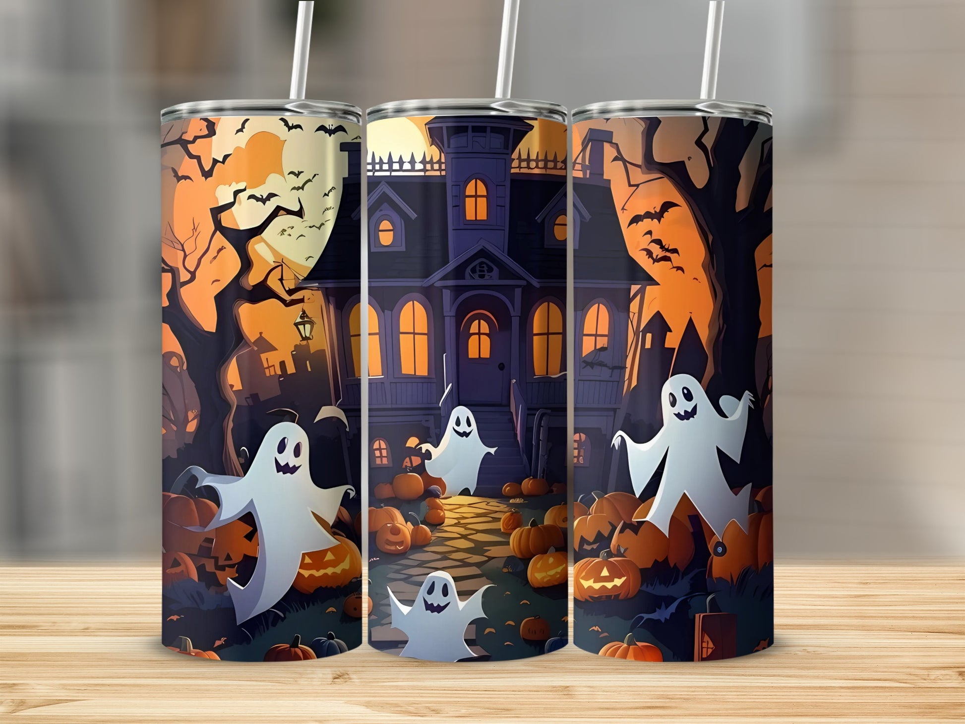 Three tumblers with a Halloween theme featuring ghosts, pumpkins, and a haunted house.