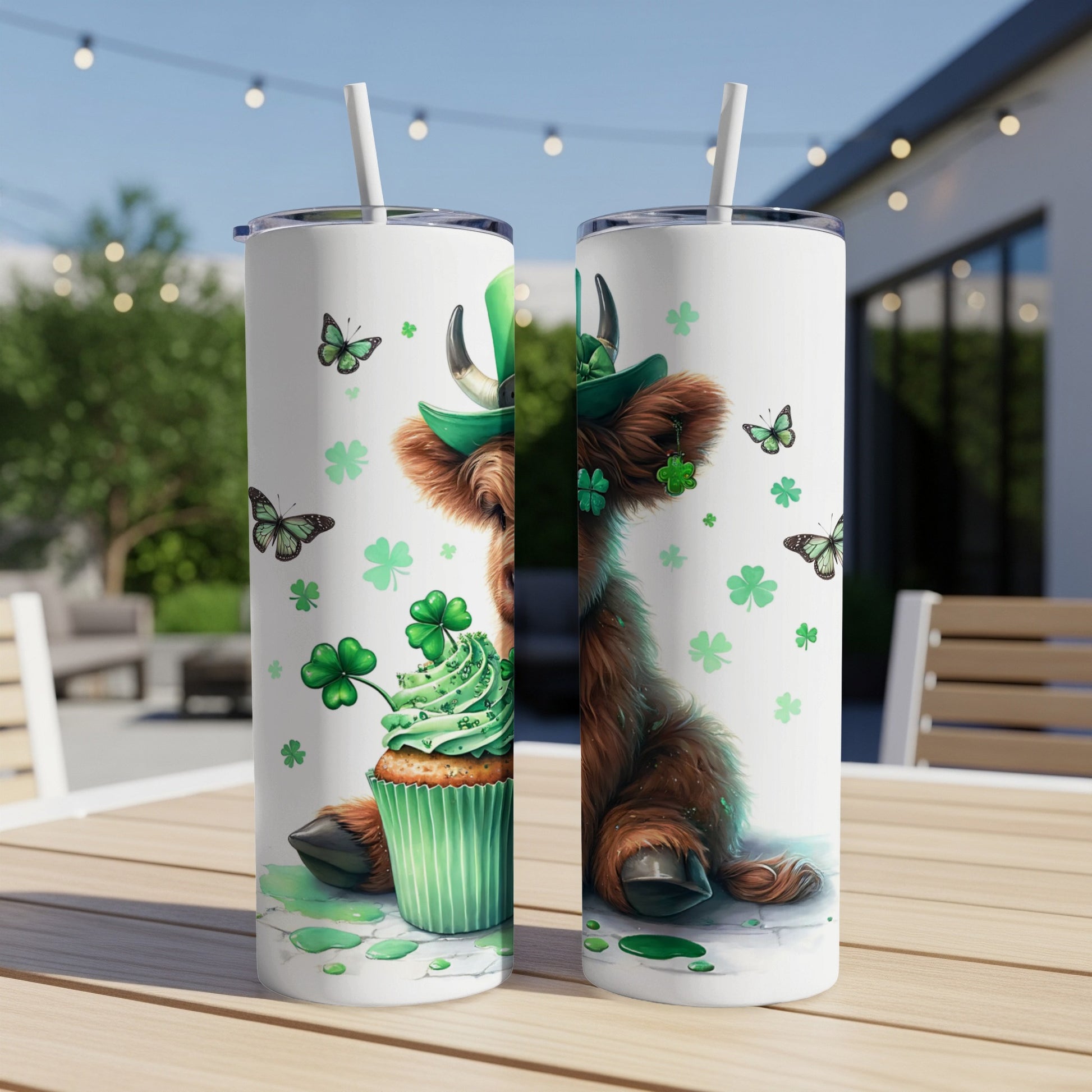 Highland cow in green hat with cupcake and shamrocks on a tumbler.
