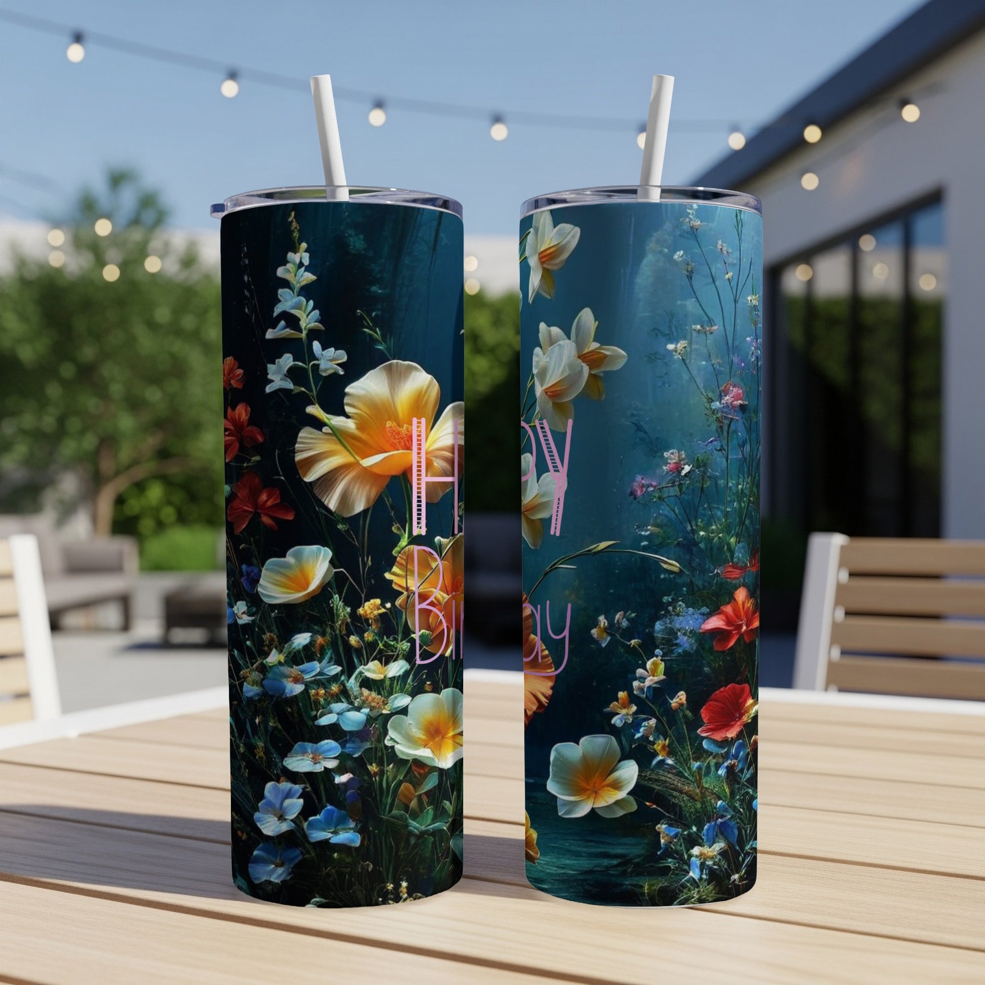 Two tumblers with floral art and "Happy Birthday" text outdoors.