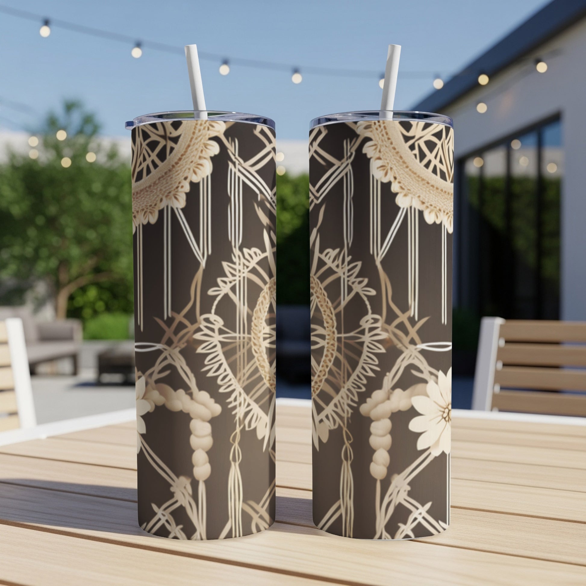 Two brown tumblers with a geometric boho pattern and straws on a table.