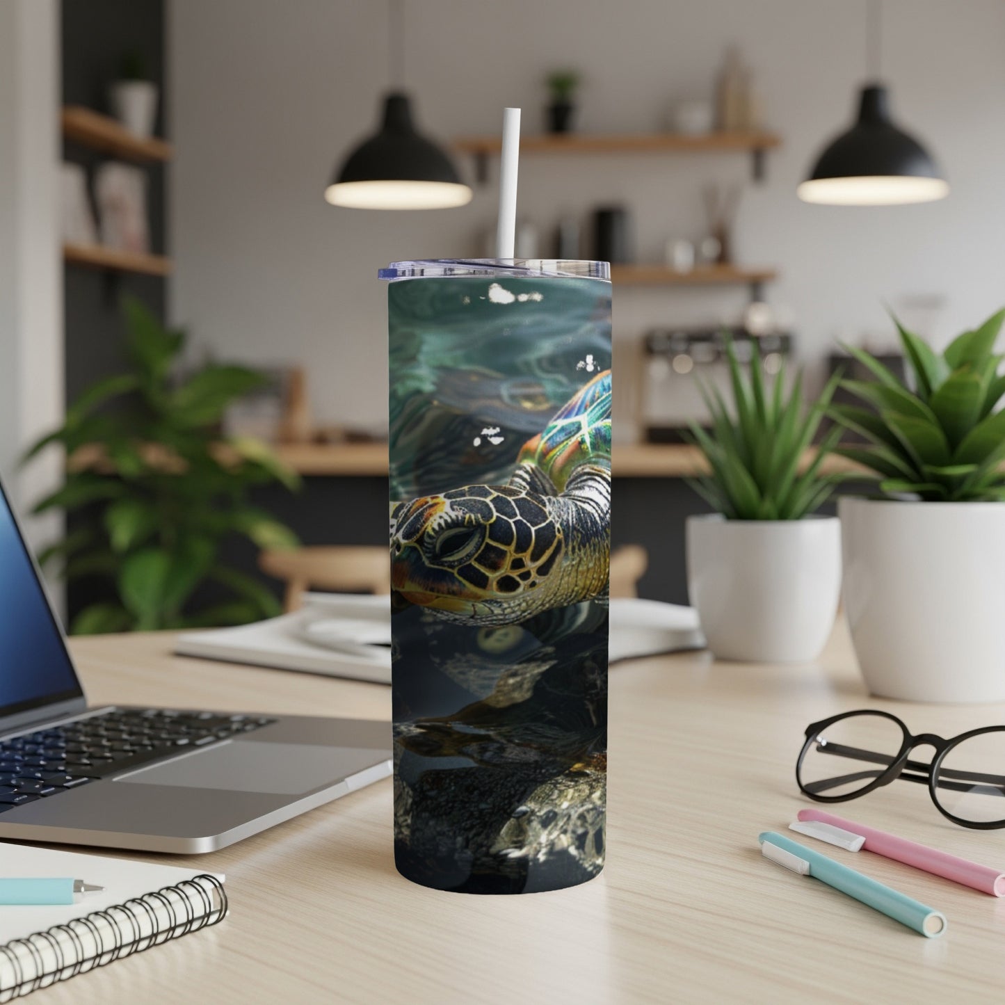 Sea turtle swimming underwater on a stainless steel tumbler with straw.