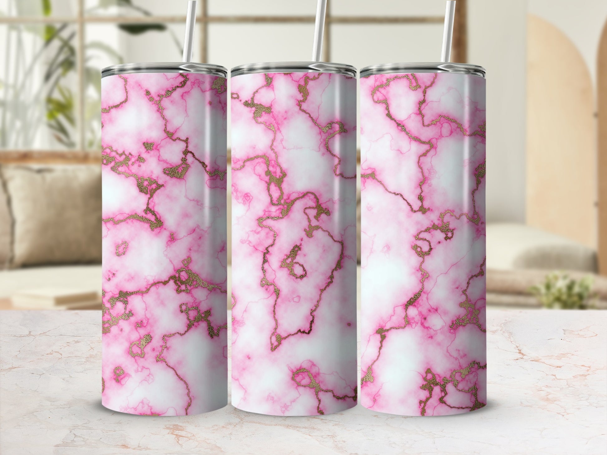 Three pink marble tumblers with gold veining on a countertop.