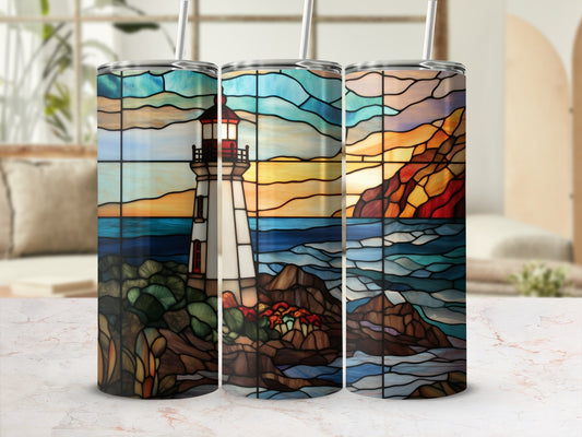 Three tumblers with stained glass lighthouse scene on rocky shore.