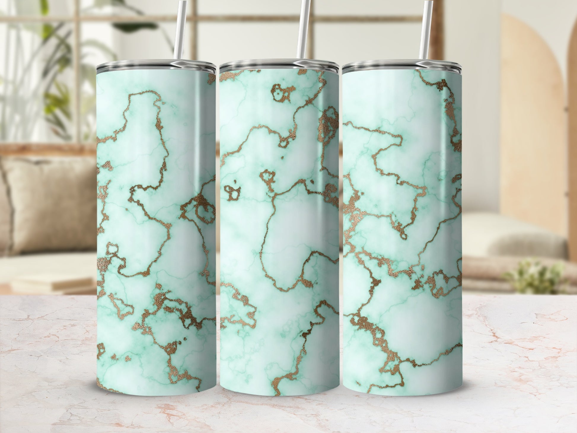 Three mint green and gold marbled tumblers with straws.