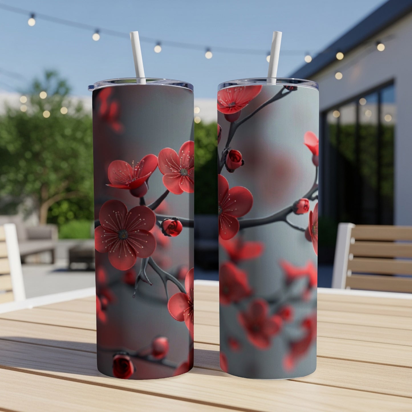 Two tumblers with red cherry blossoms on gray background.