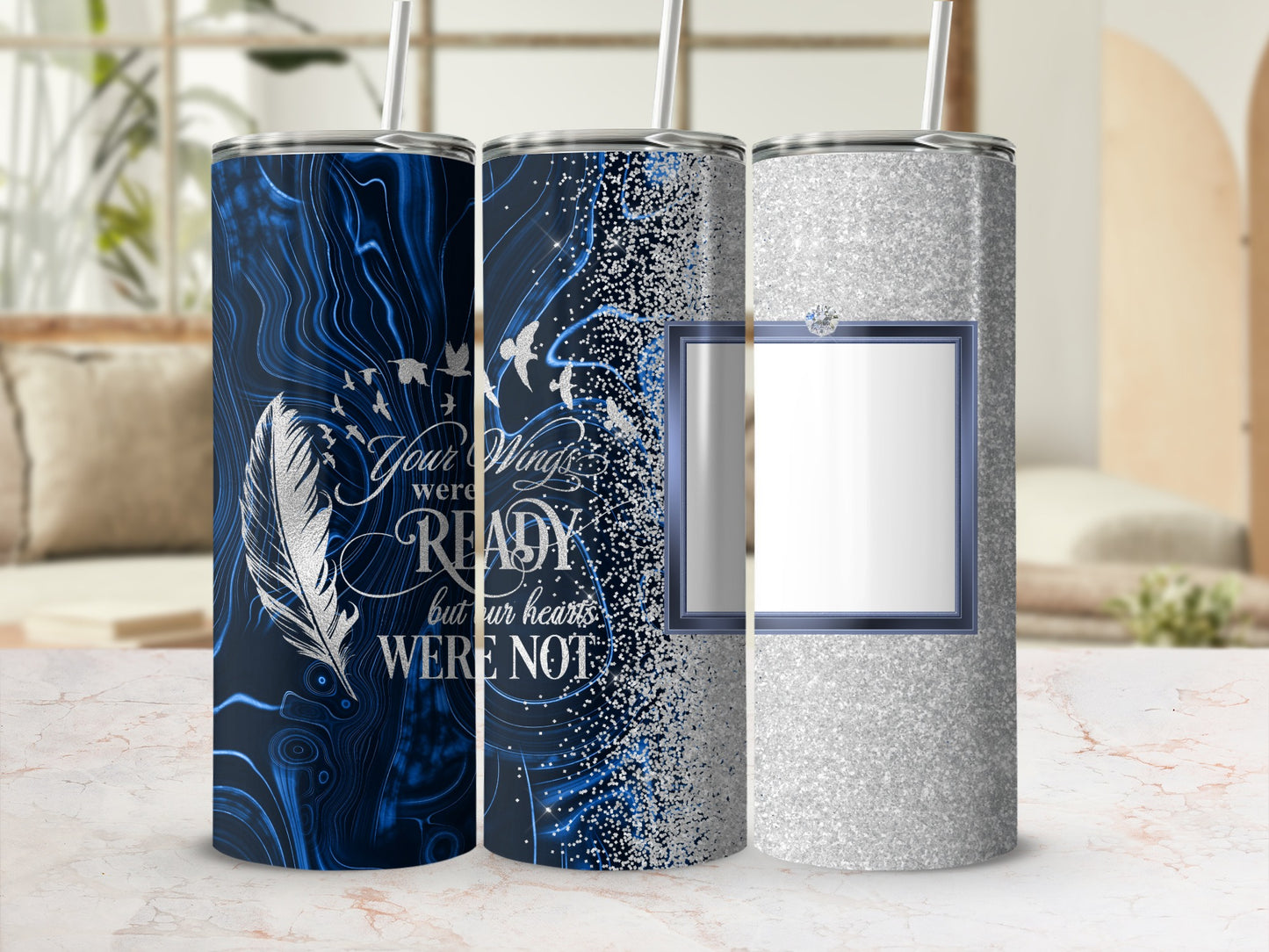 Three tumblers: one with blue swirls, one with feathers and text, one glittery silver.