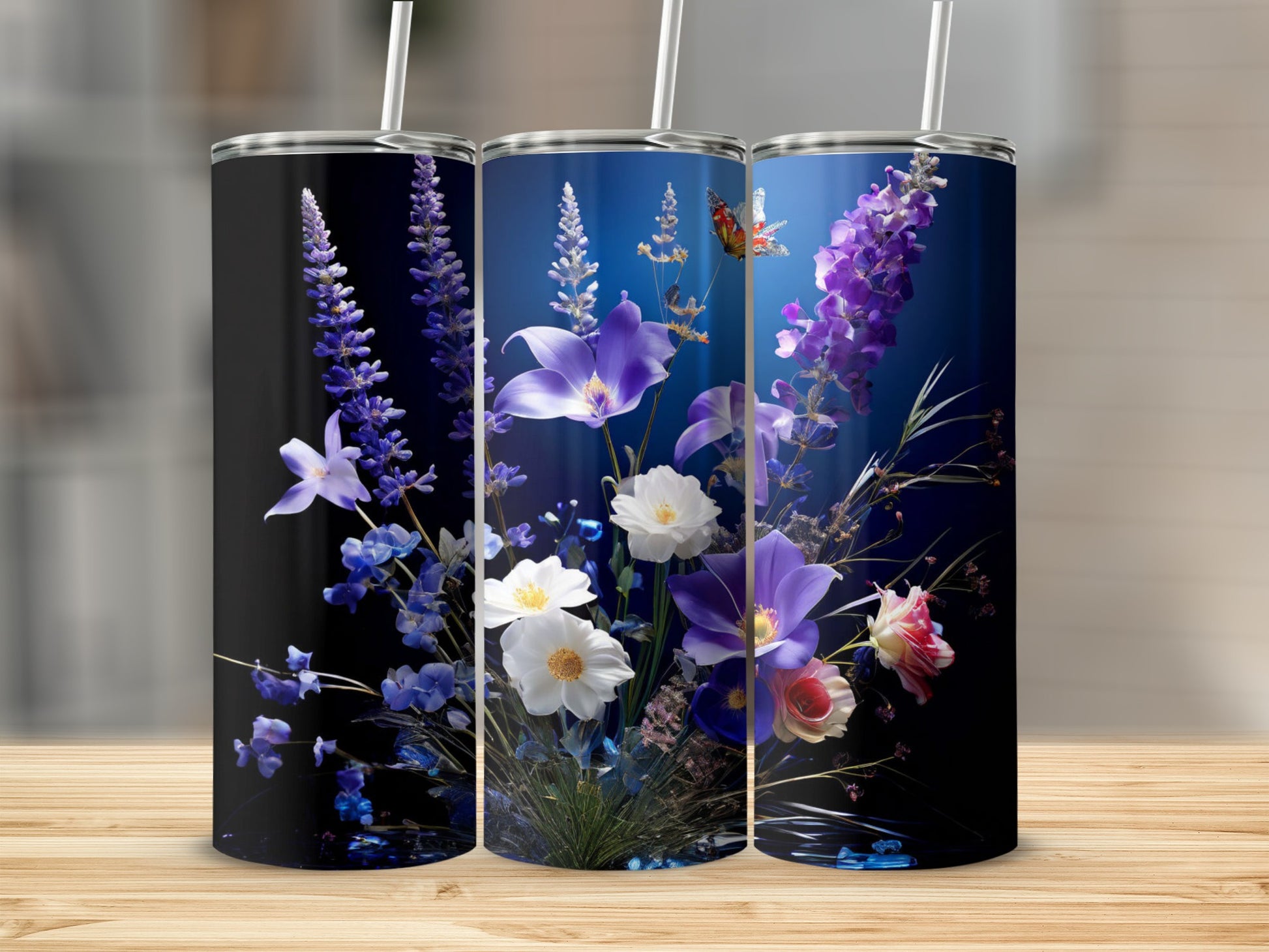 Three tumblers with colorful floral designs featuring purple and white flowers.