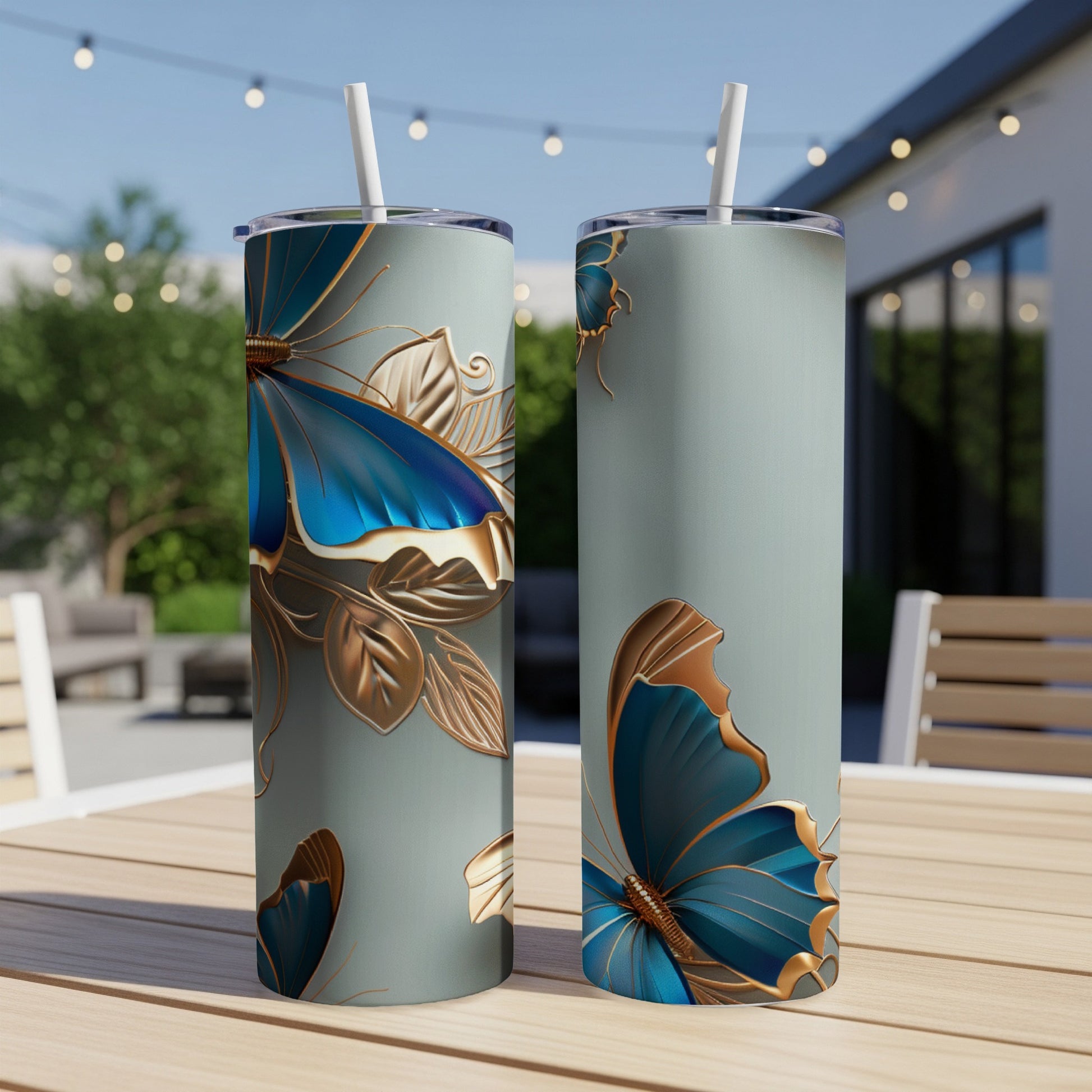 Two blue and gold butterflies on mint green tumblers with straws.