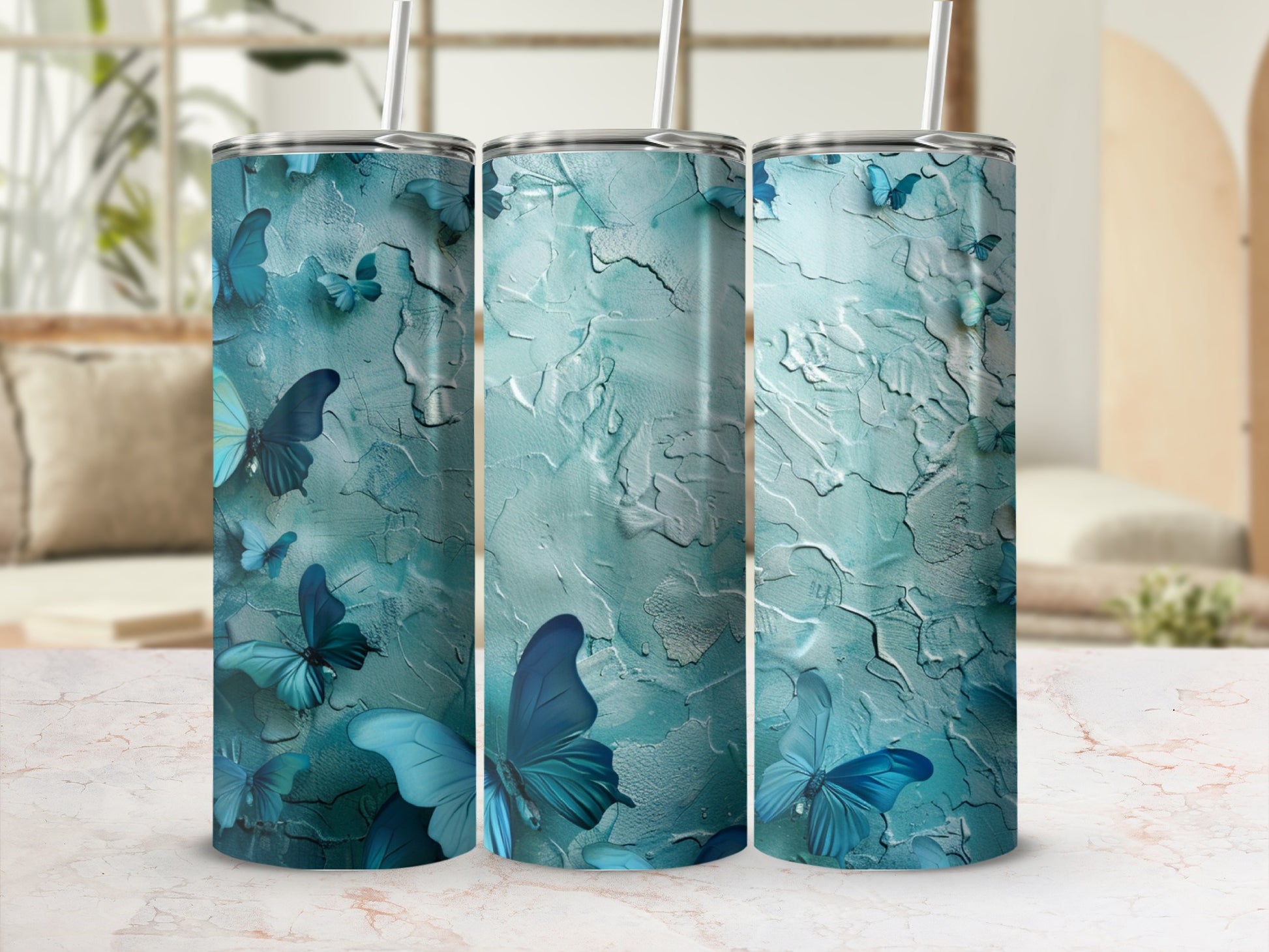 Three teal tumblers with blue butterflies and textured background.