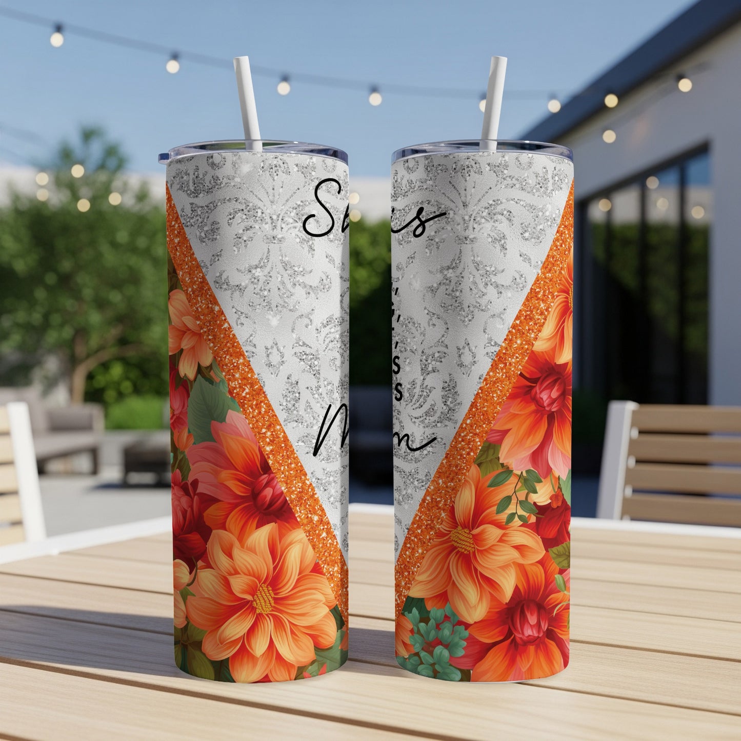 Two tumblers with "Sisters" and floral design on a table.