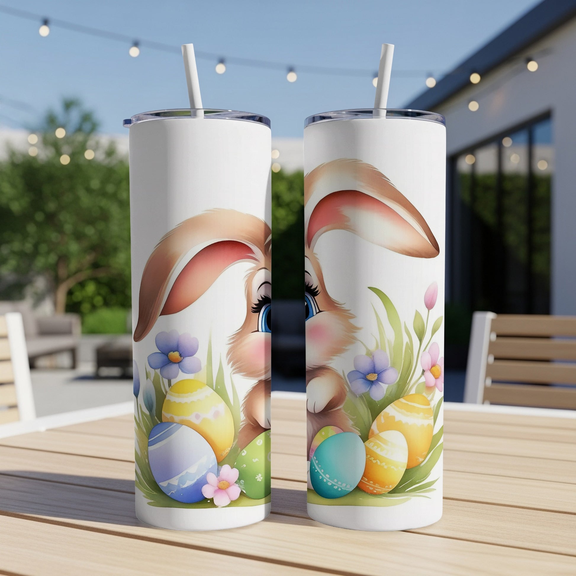 Two Easter-themed tumblers with bunnies and colorful eggs on a patio table.