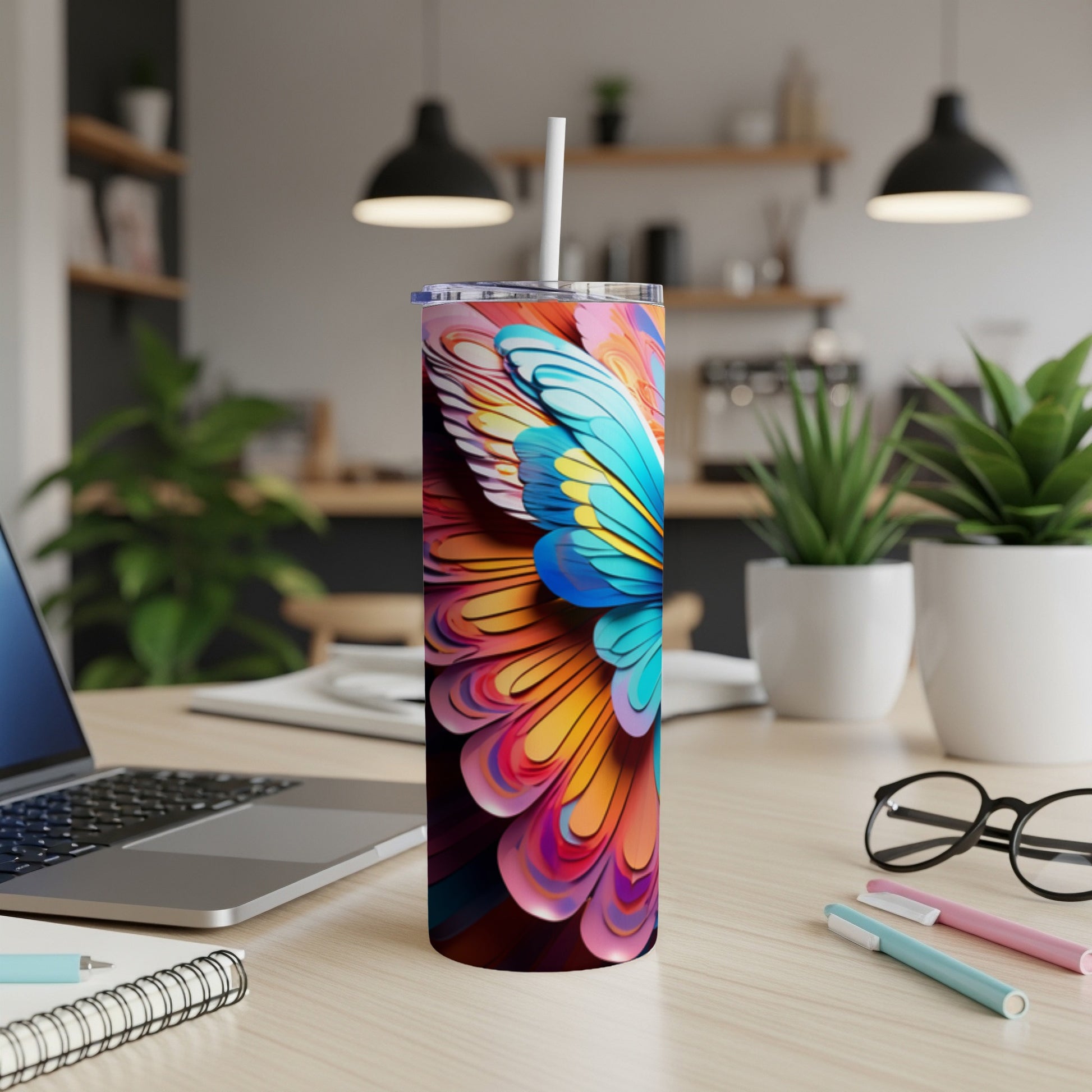 Tall tumbler with colorful butterfly wings design on a desk.